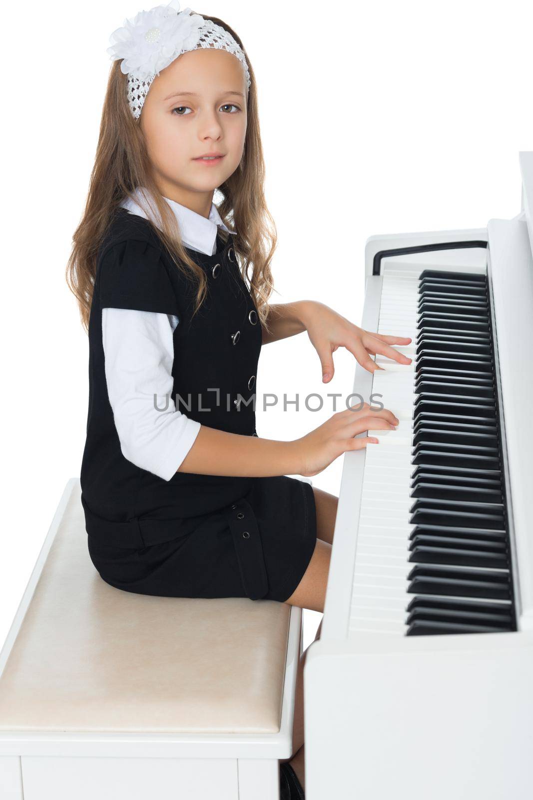 Beautiful little girl in the music school, learning to play the piano - Isolated on white background