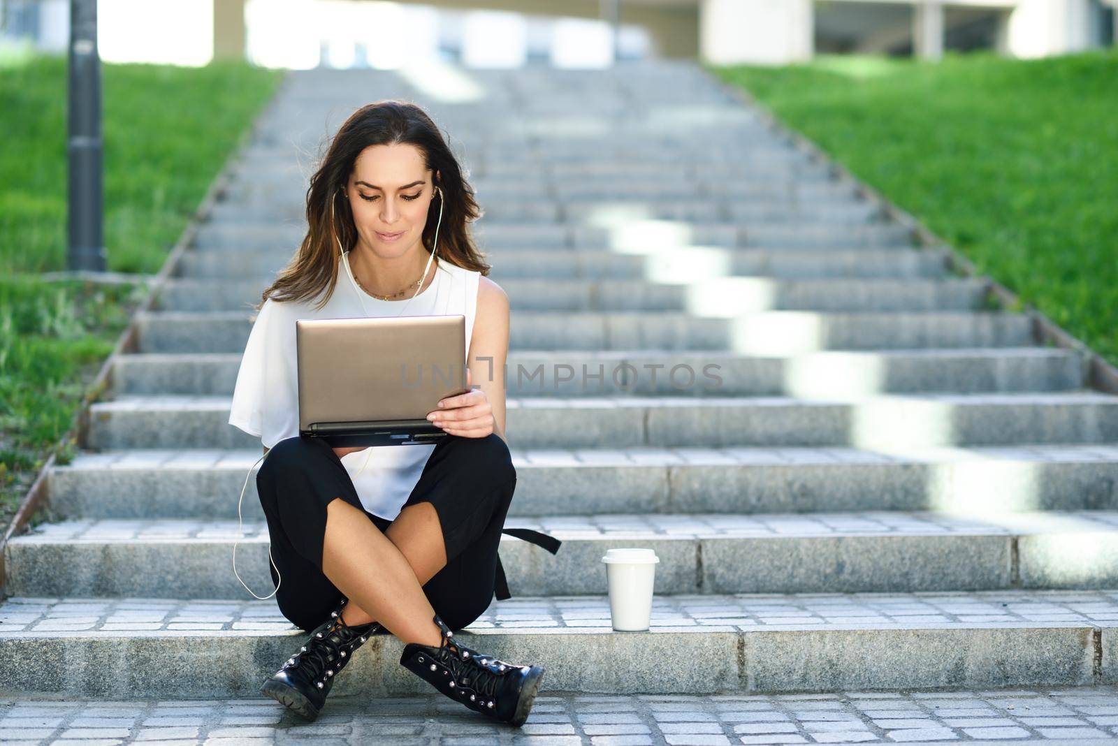 Young woman working with her laptop computer sitting on the floor. by javiindy