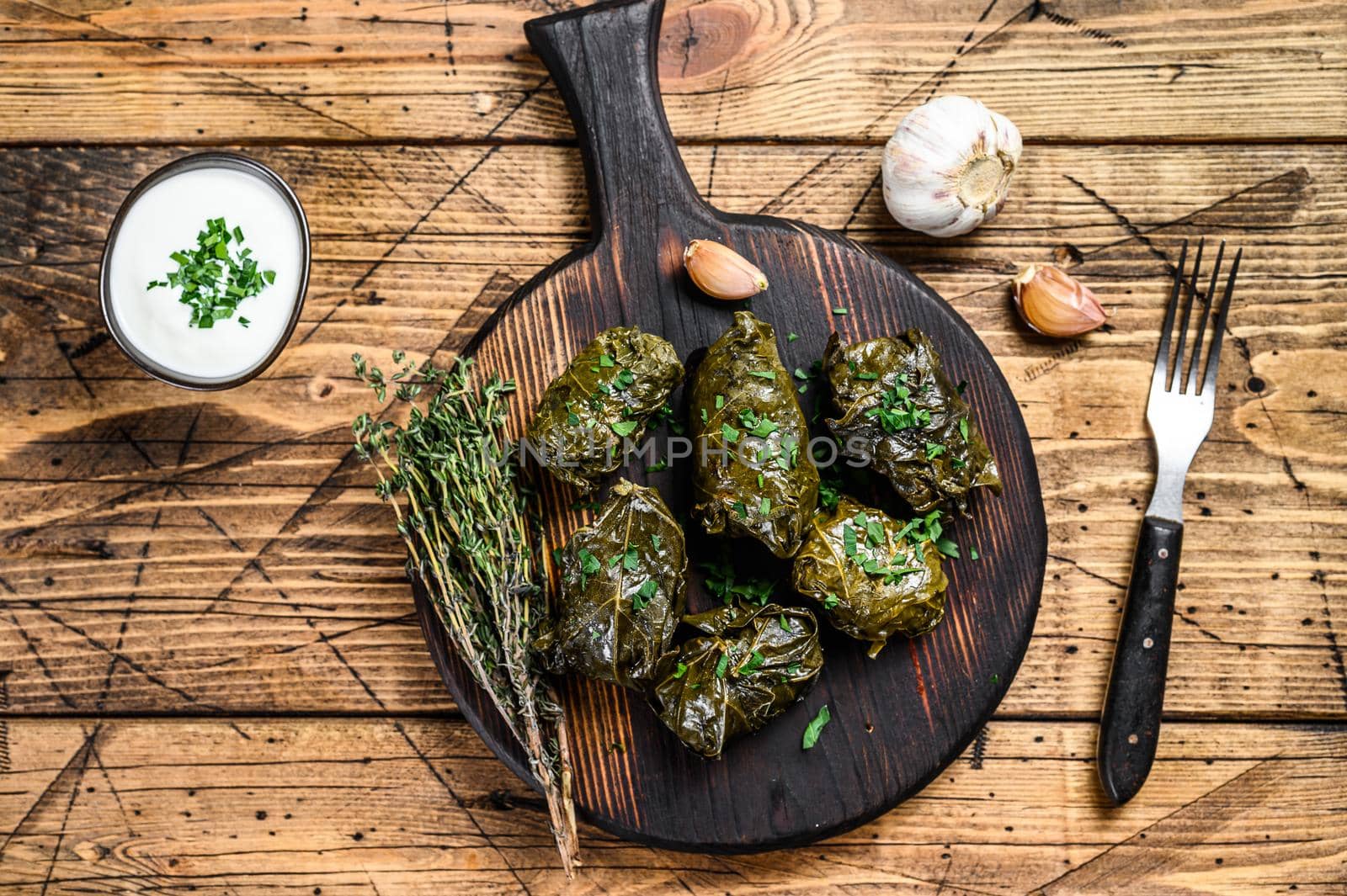 Traditional georgian dolma in grape leaves. wooden background. Top view.