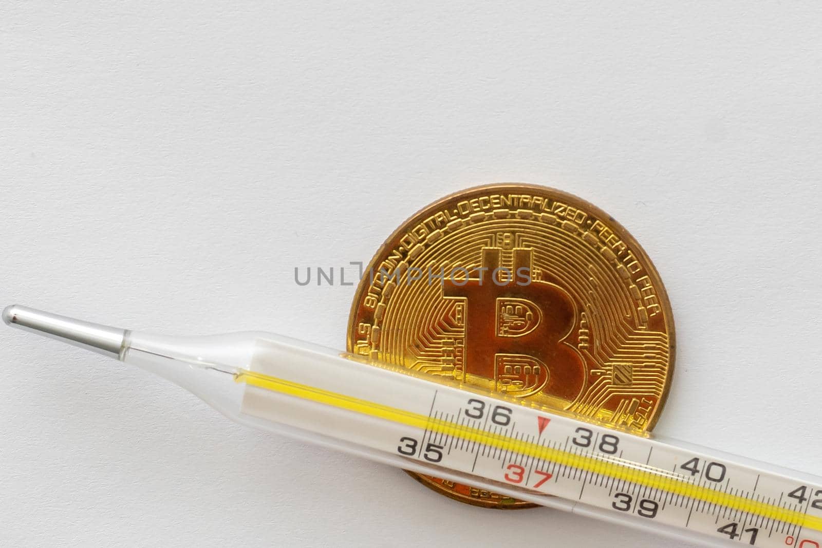 Mercury thermometer and bitcoin on white background by Andelov13