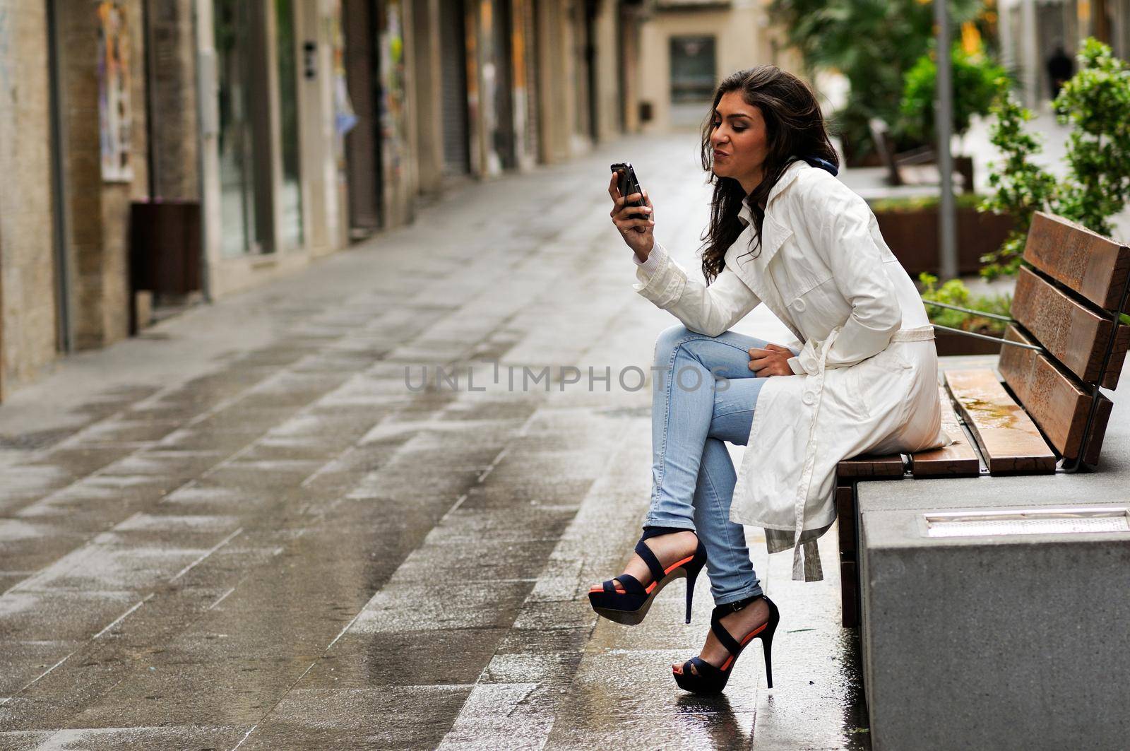 Portrait of beautiful young woman in urban background talking on phone
