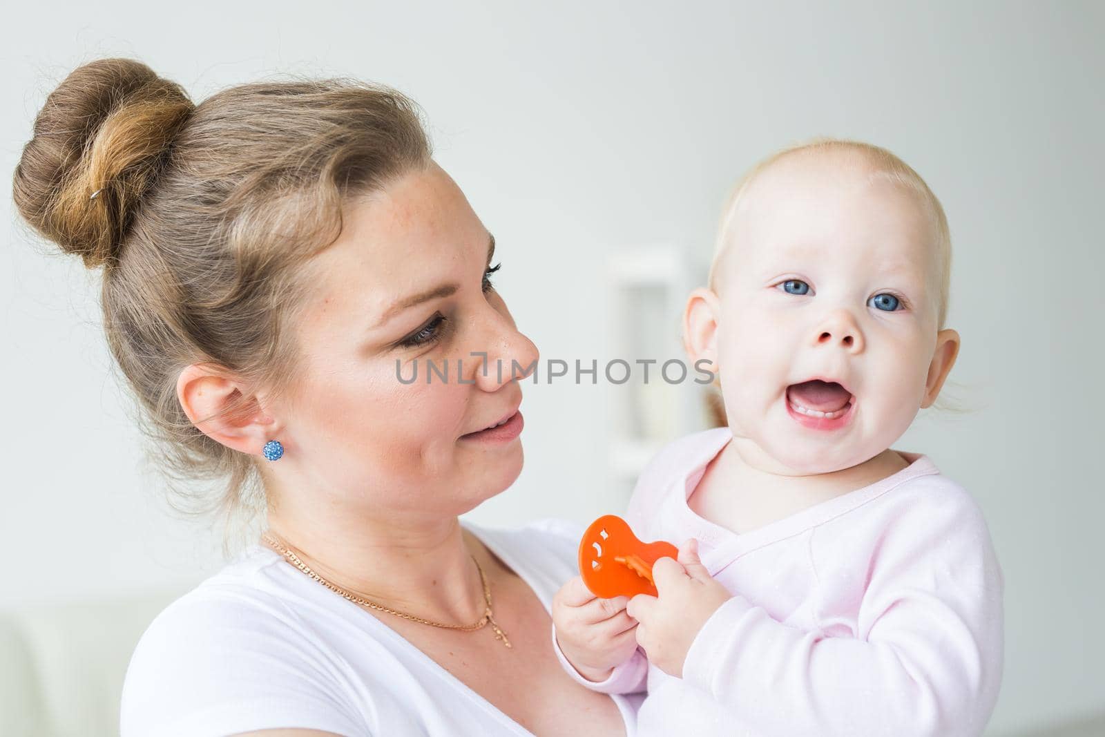 Childhood, family and motherhood concept - Mother holding sweet baby girl close-up by Satura86