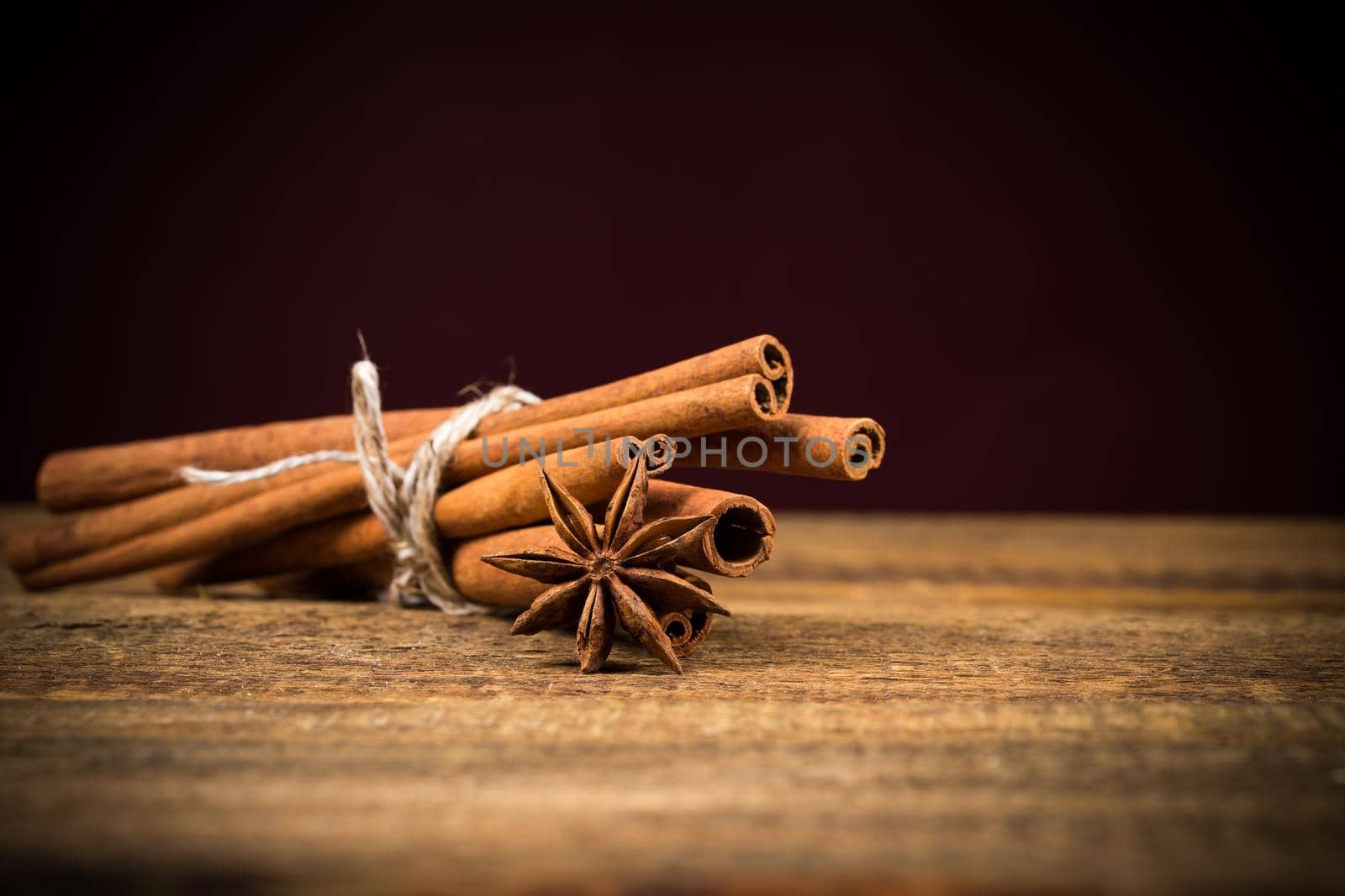 Close up of cinnamon sticks and star anise on rustic wood background