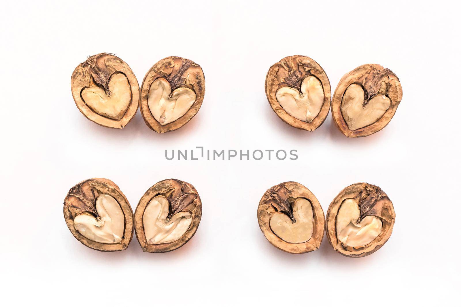 Halves of a walnut in the shape of a heart isolated on a white background.