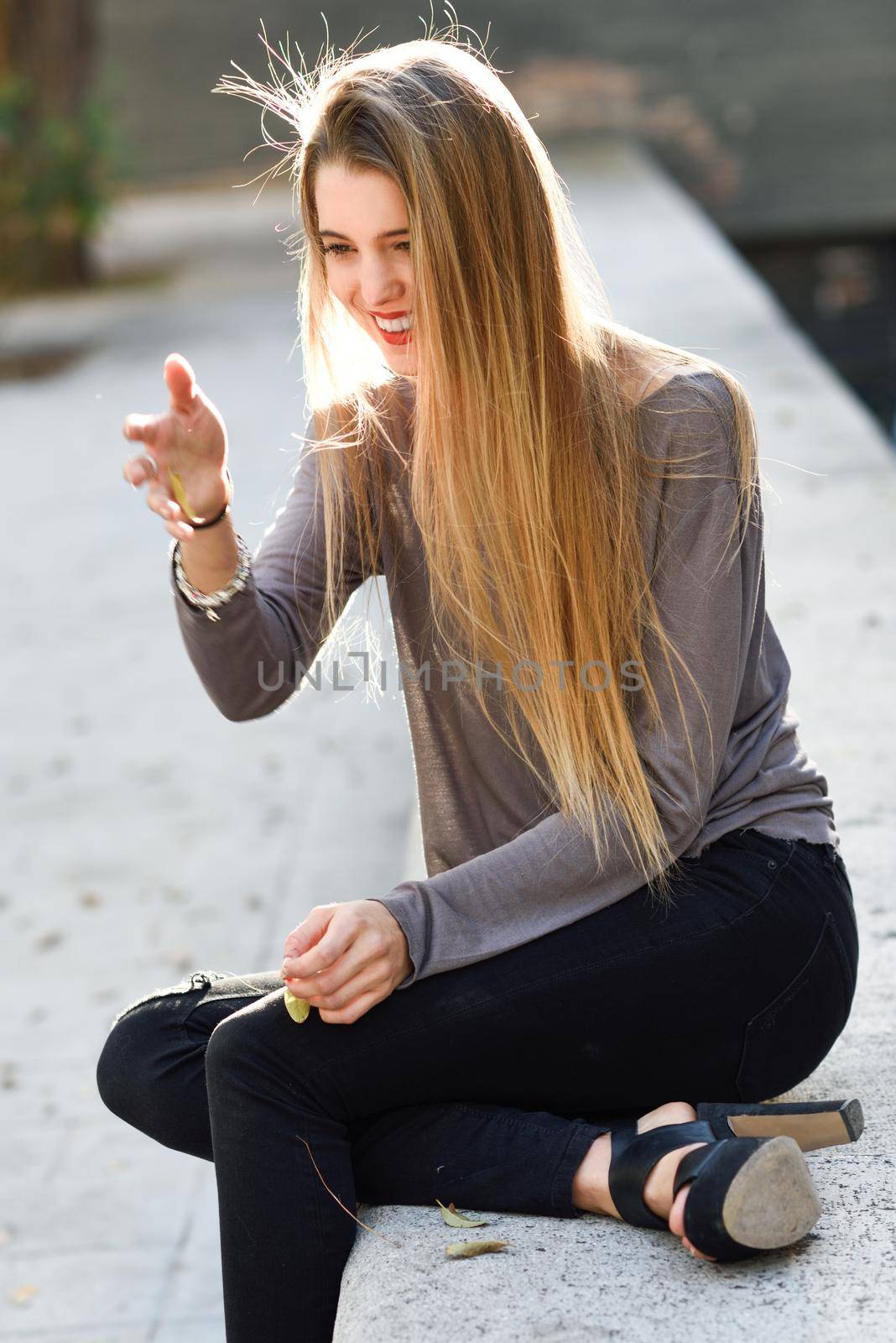 Portrait of happy blonde girl smiling in urban background