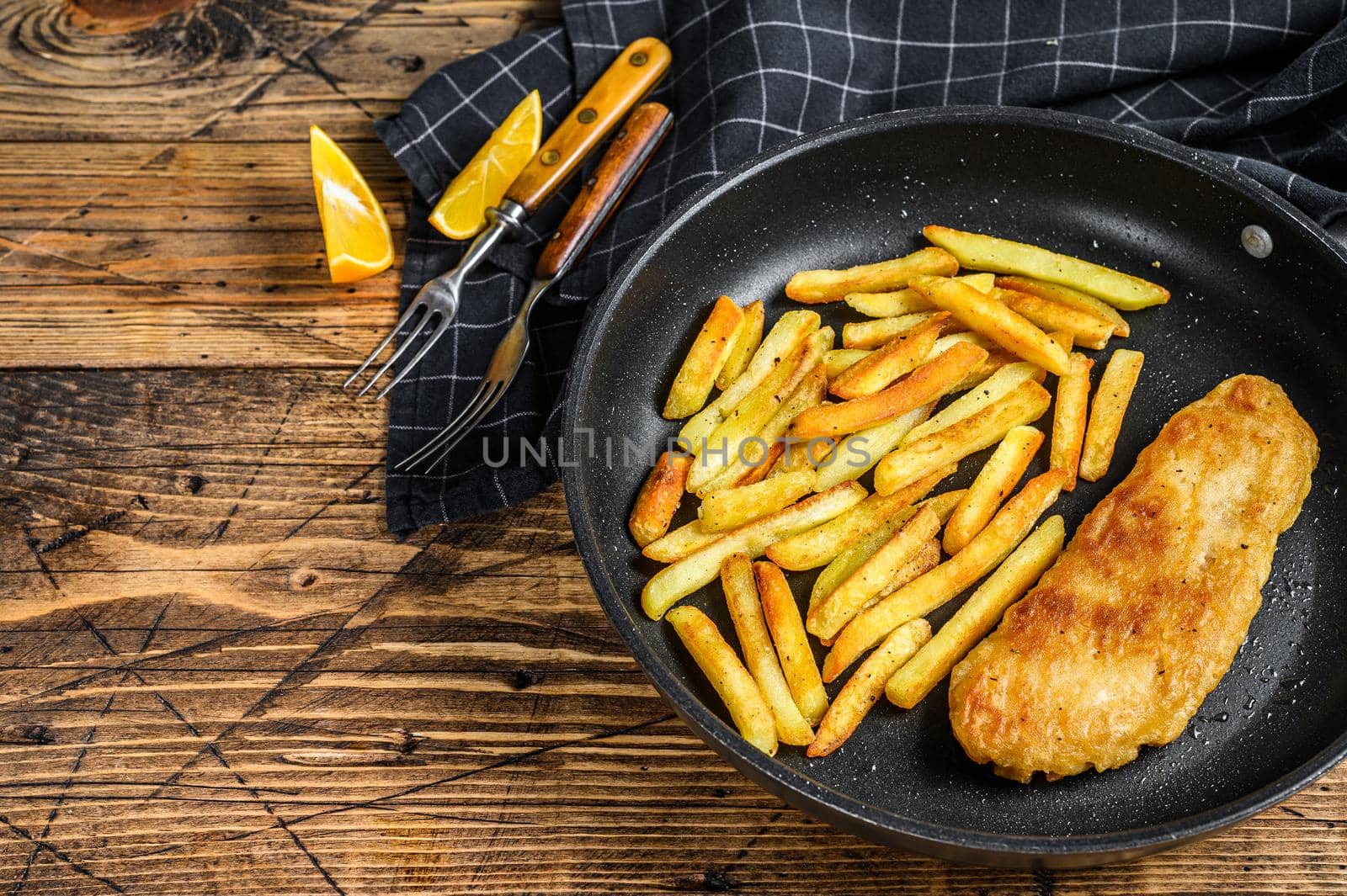 English Traditional Fish and chips dish in a pan. Wooden background. Top view. Copy space.