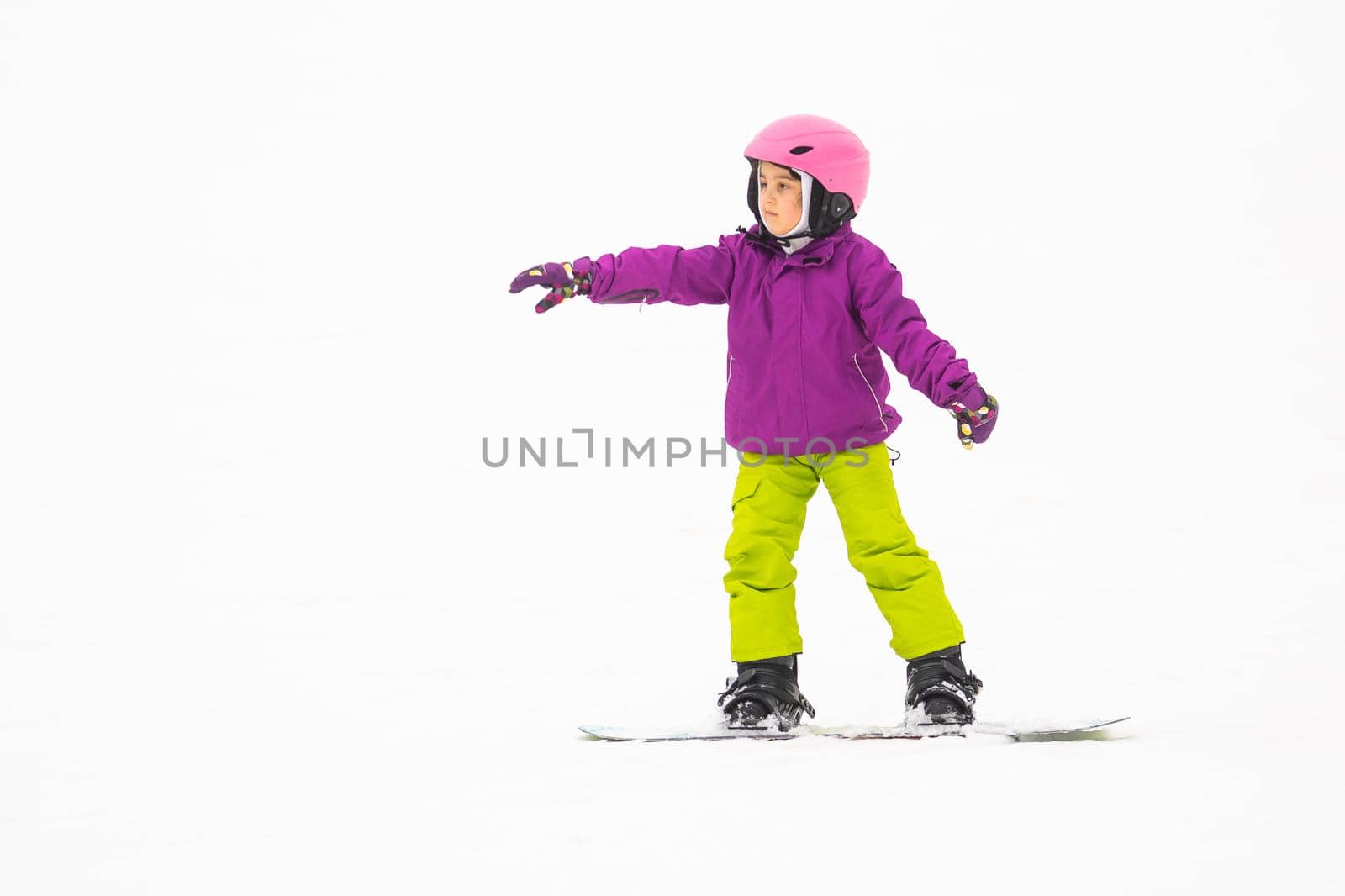 Little Cute Girl Snowboarding at ski resort in sunny winter day. by Andelov13