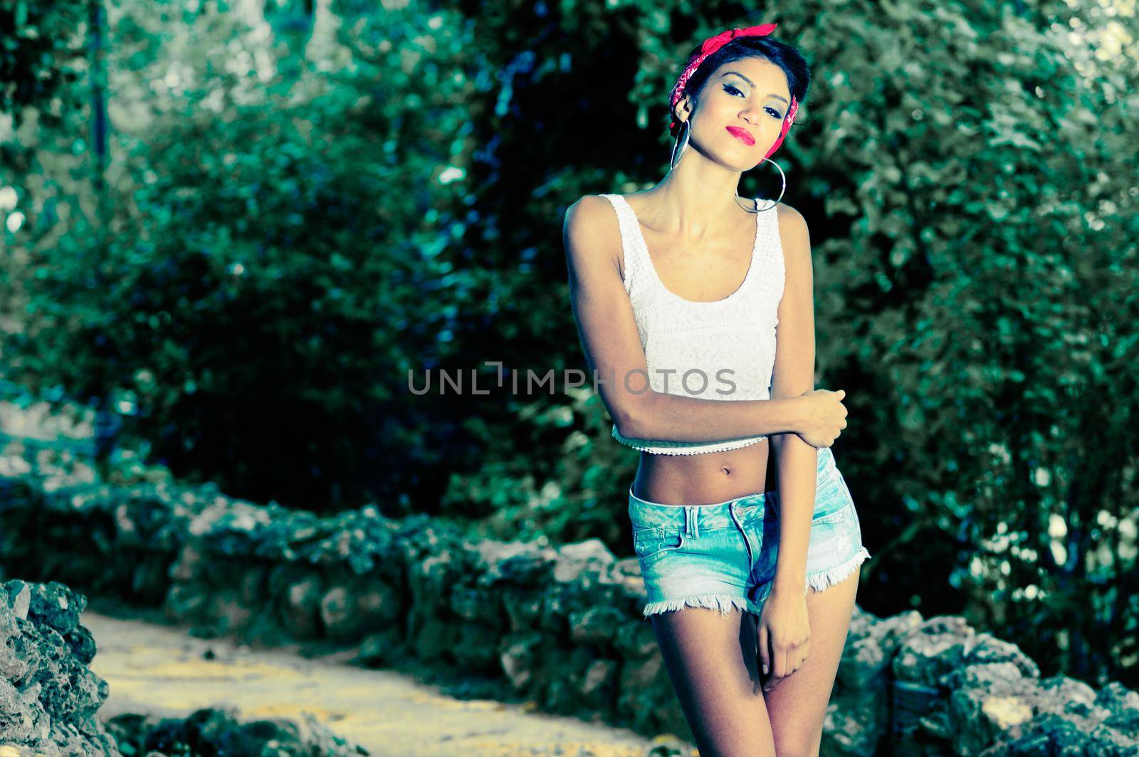 Portrait of a pin-up girl. American style, in a garden, wearing jeans and t-shirt