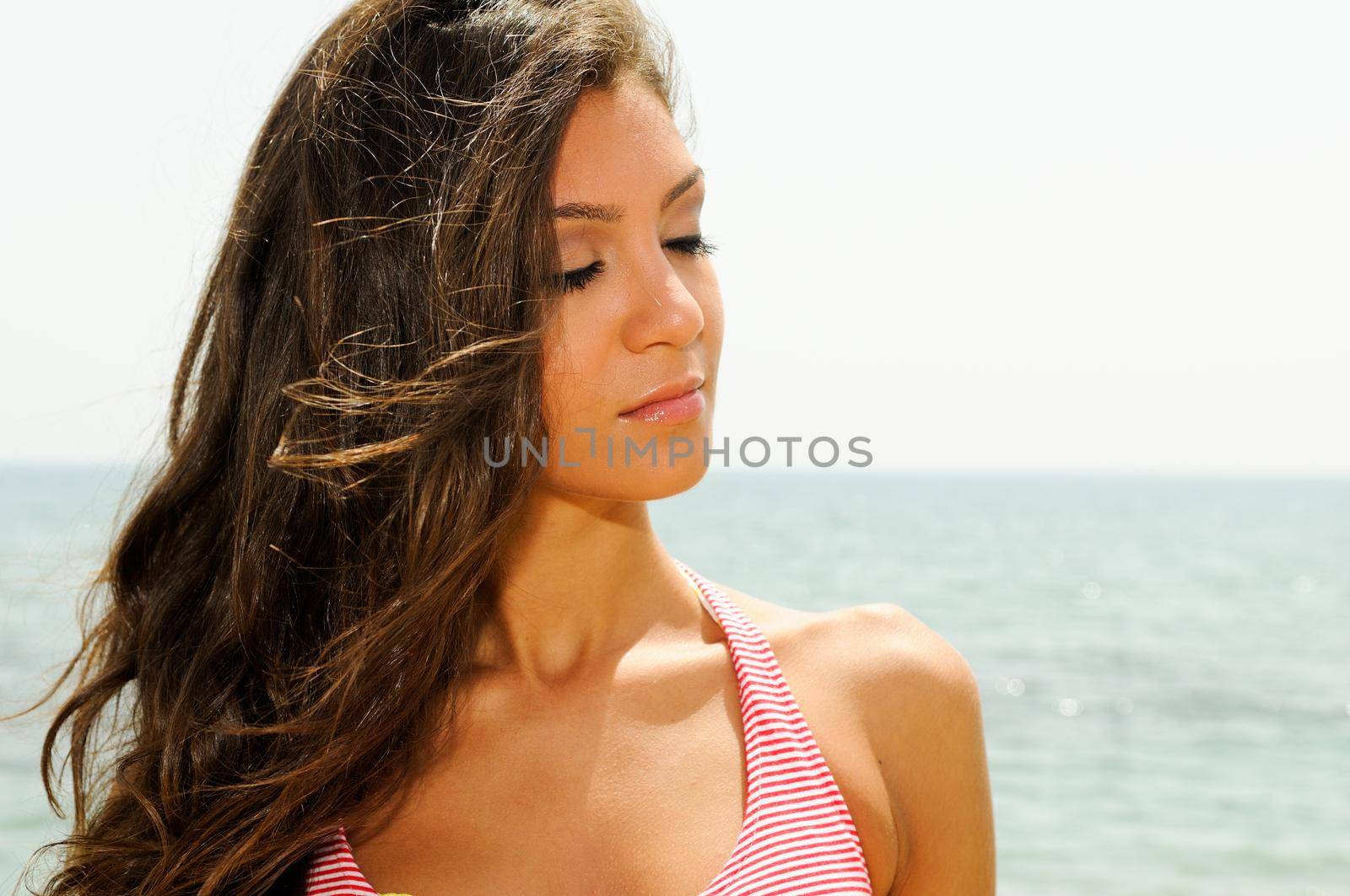 Portrait of a beautiful woman with long pink dress on a tropical beach