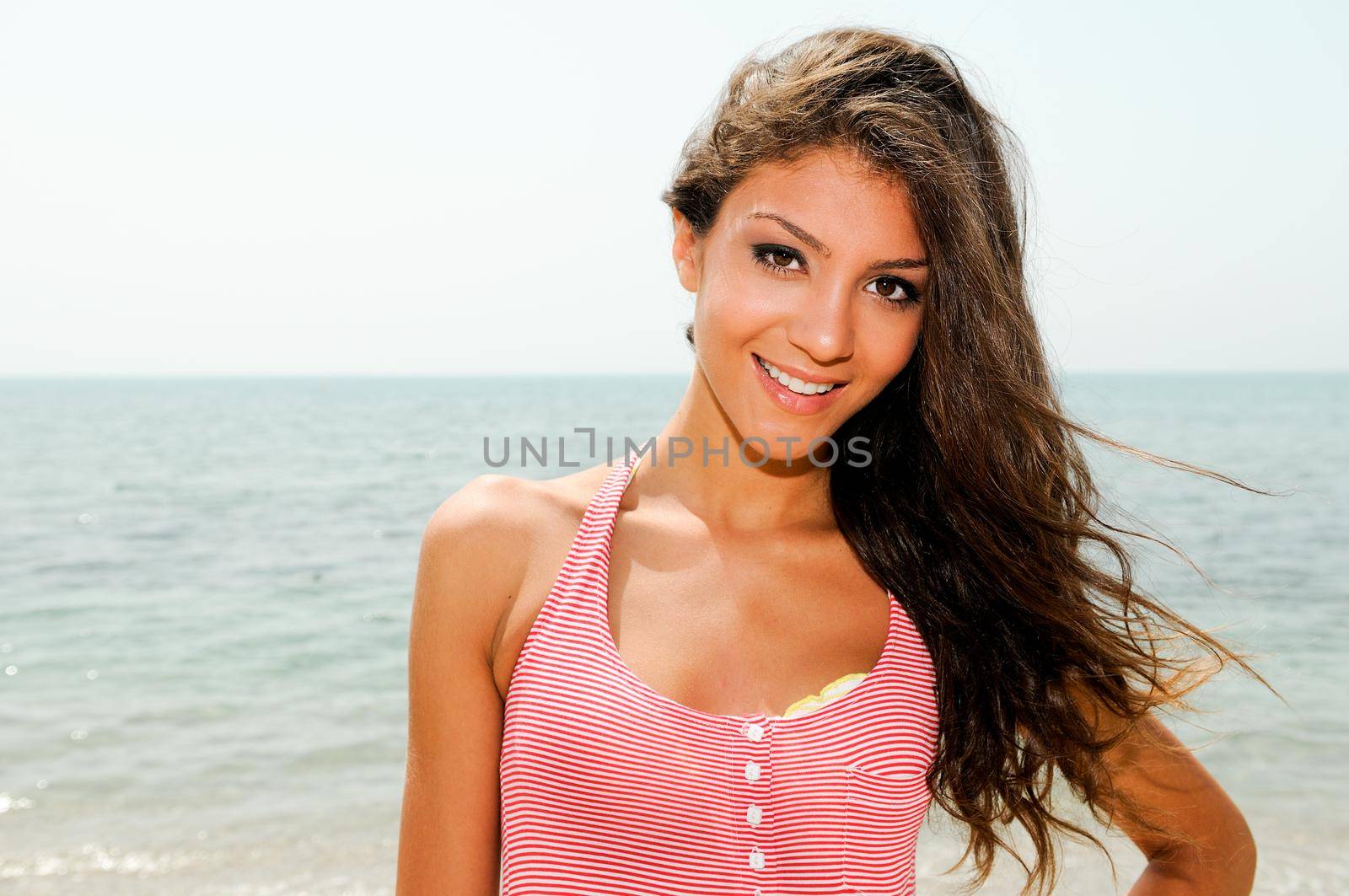 Portrait of a beautiful woman with long pink dress on a tropical beach