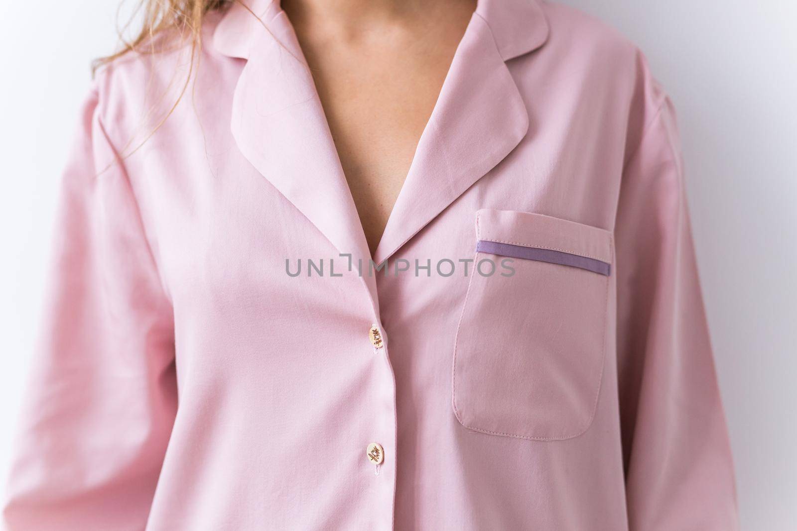 Close-up of woman dressed in beautiful pink pajama posing in her living room. Comfortable sleepwear, home relaxation and female fashion concept. by Satura86