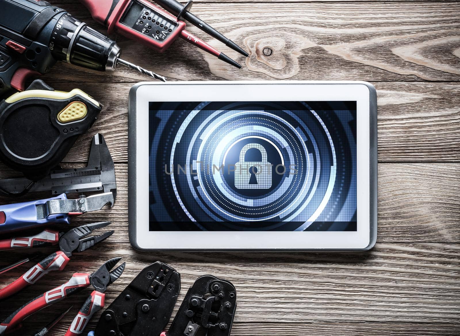 Tablet pc with security concept on screen and industrial tools around