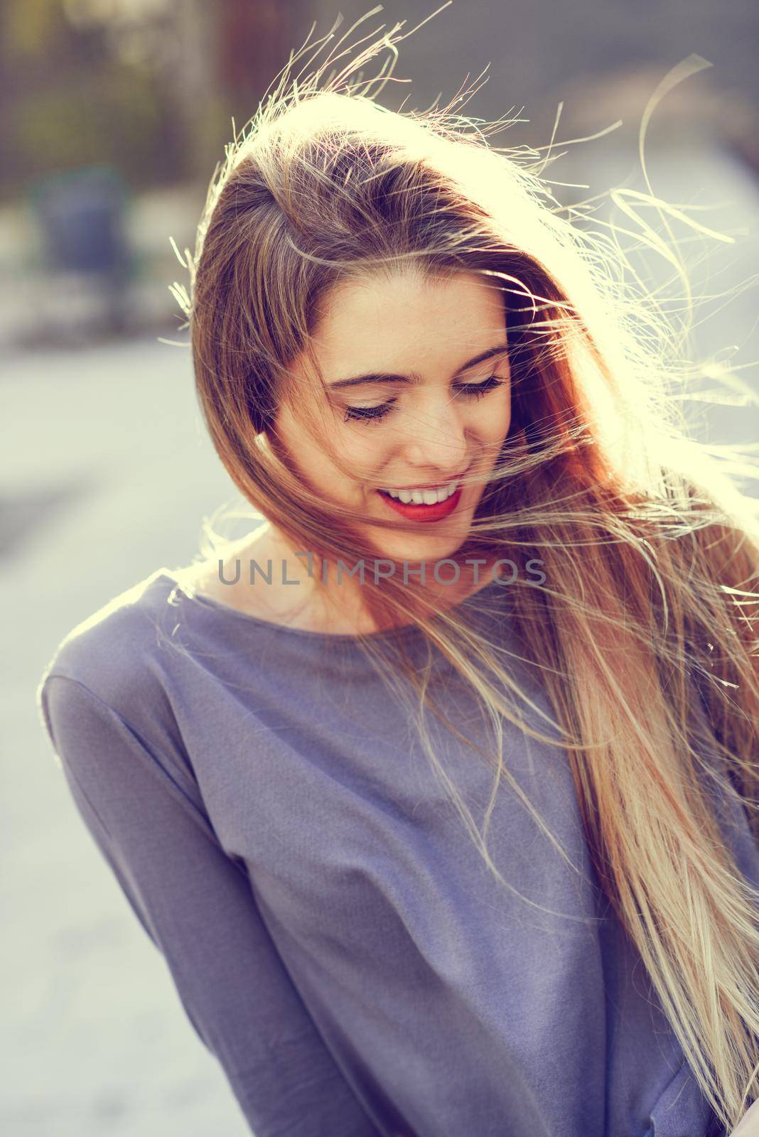 Portrait of happy blonde girl in urban background