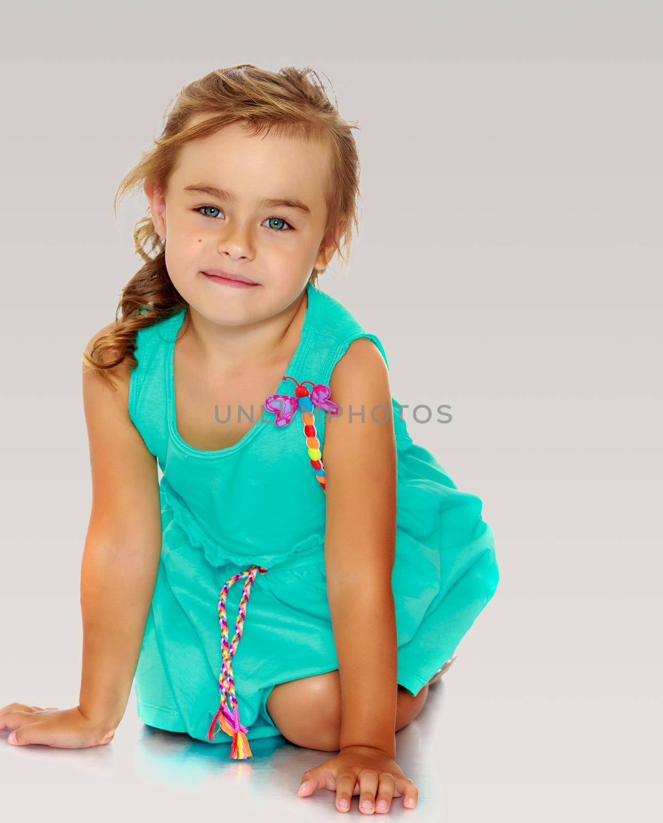 Little girl in blue dress on her knees by kolesnikov_studio