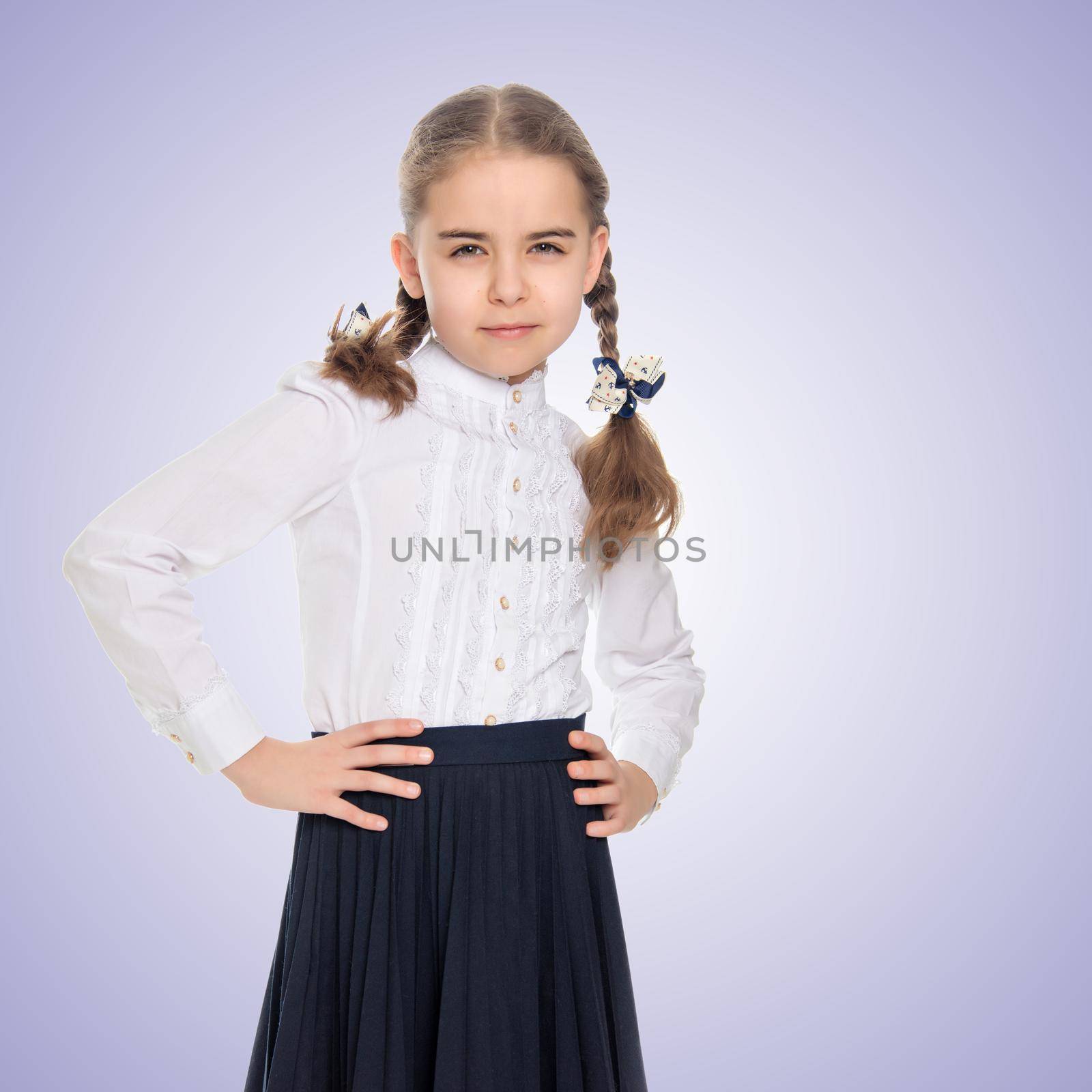 A beautiful little schoolgirl girl in a white blouse and black long skirt, with neatly braided pigtails on her head.She is posing in front of the camera, her hands on her hips.Purple gradient background.