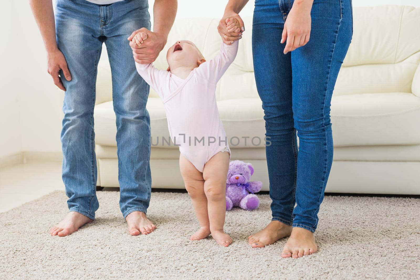 First steps. Little baby girl learning to walk. Studio shoot on white background