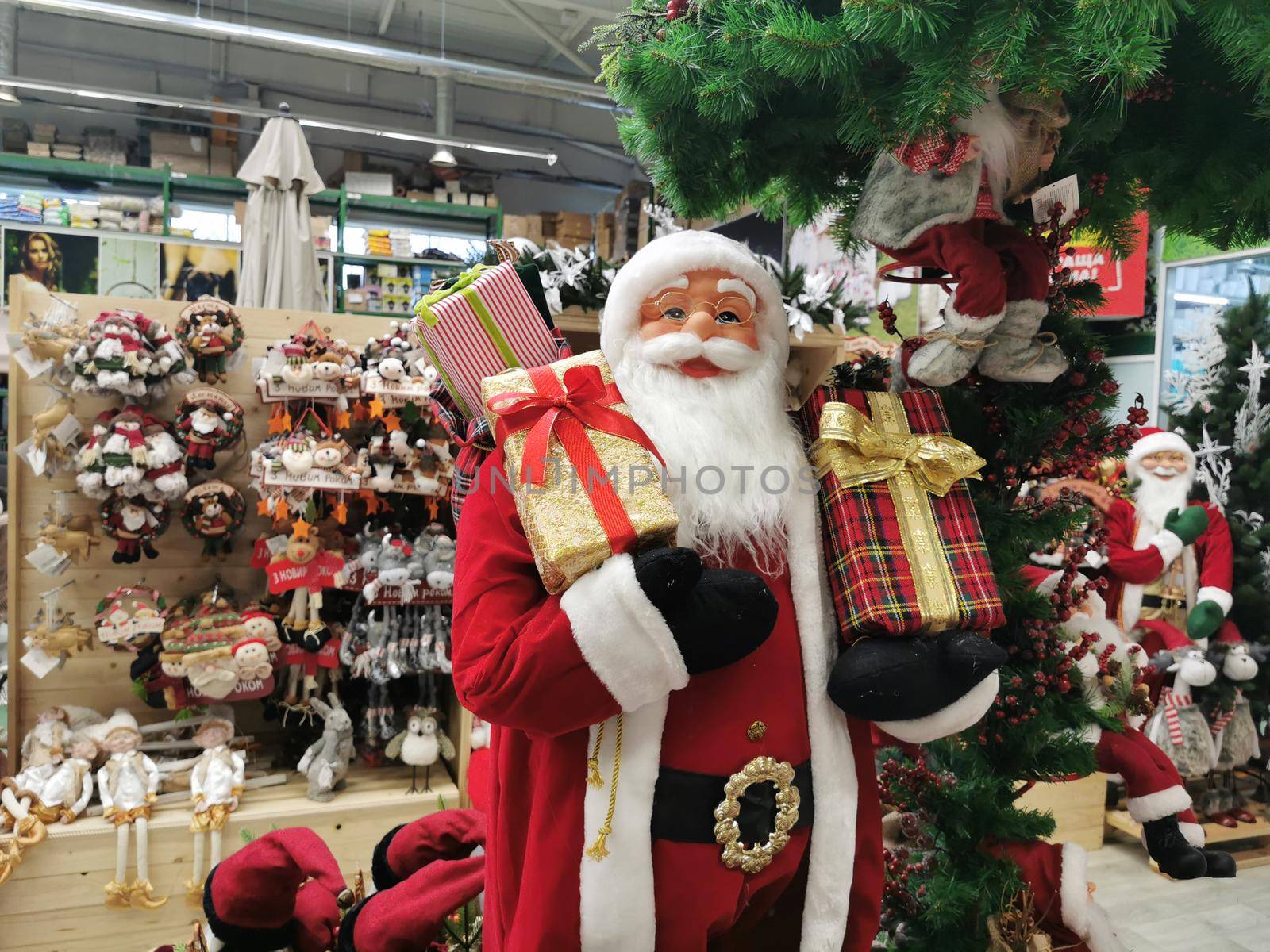 Many Santa Claus toys on a supermarket shelf for sale. Christmas collection in the store. Xmas decorations Manufacturers & suppliers concept. New Year.