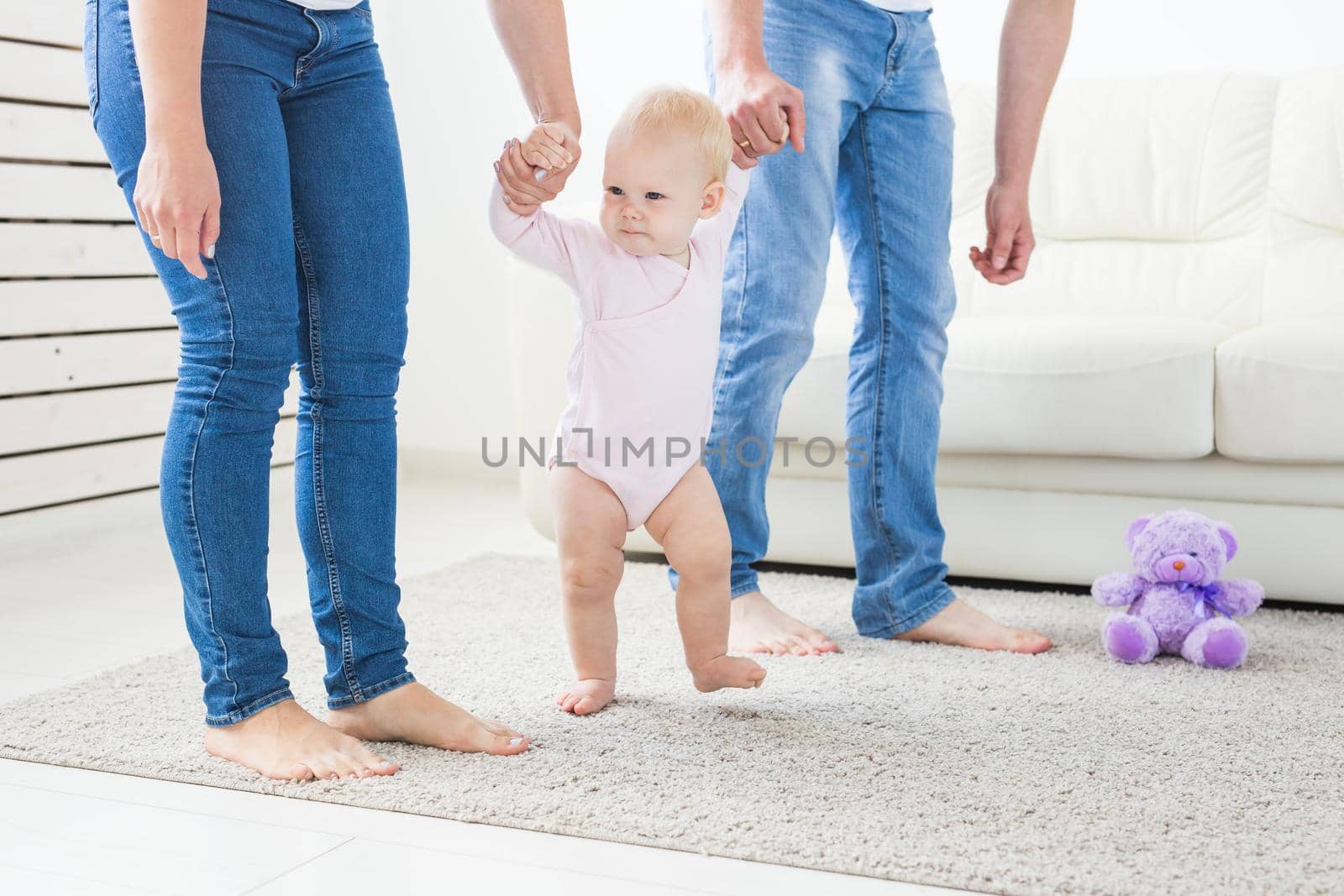 First steps. Little baby girl learning to walk. Studio shoot on white background