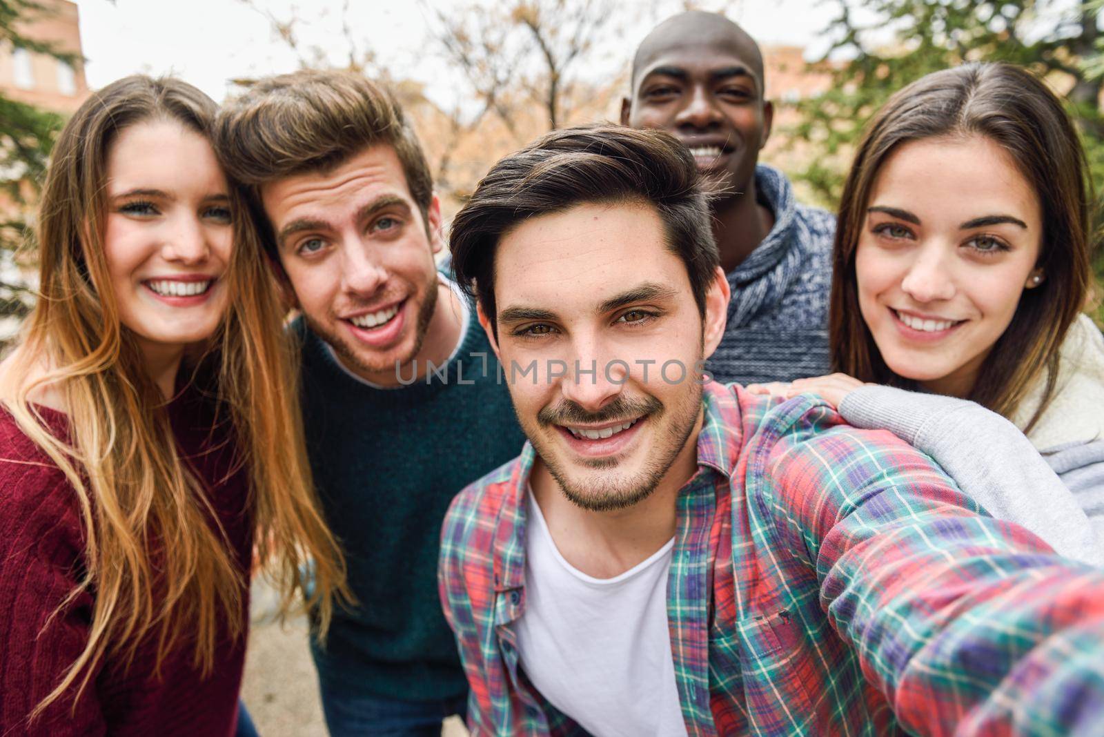 Group of multi-ethnic young people having fun together outdoors in urban background