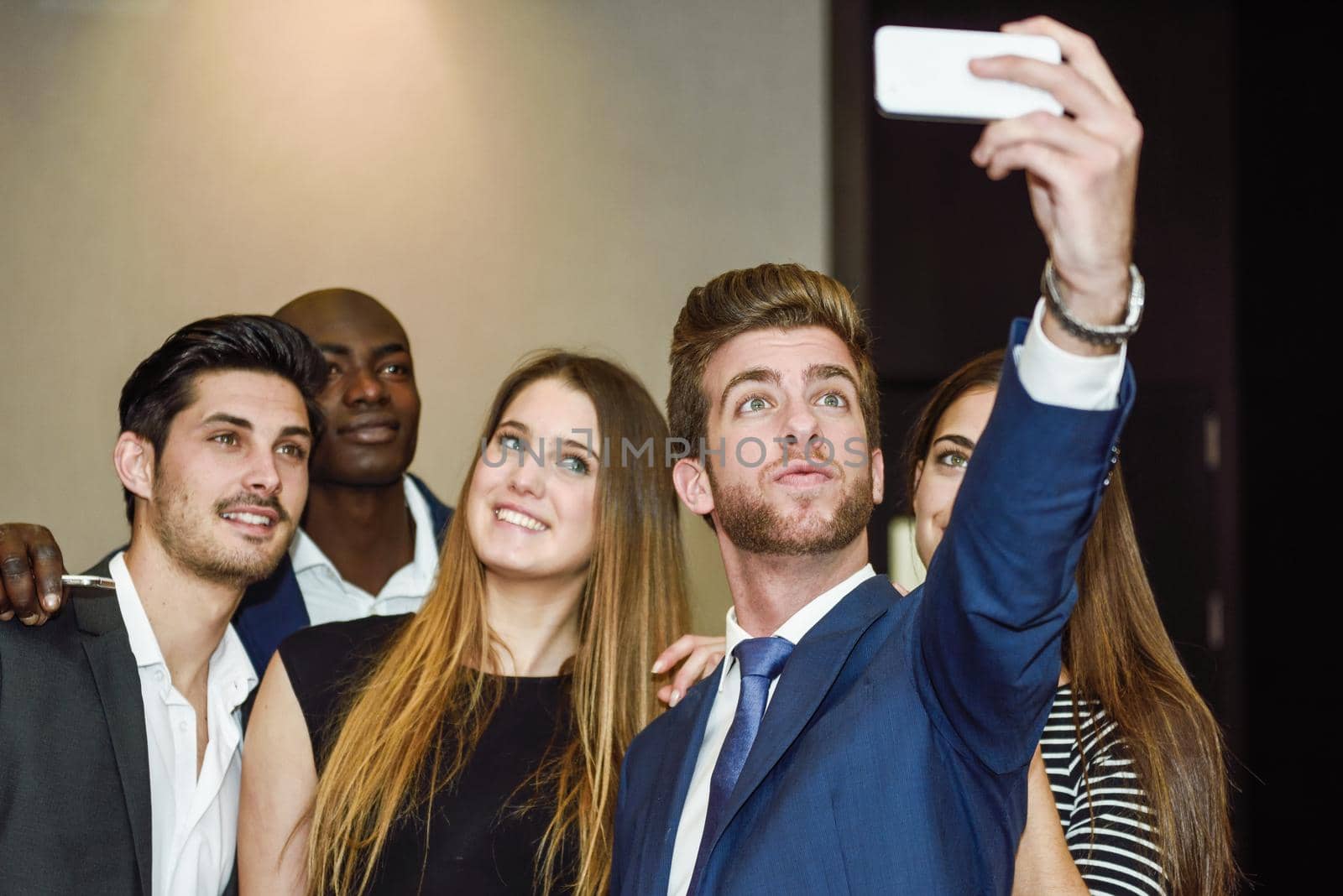 Group of multi-ethnic businesspeople taking a picture themselves with a mobile phone after a business meeting