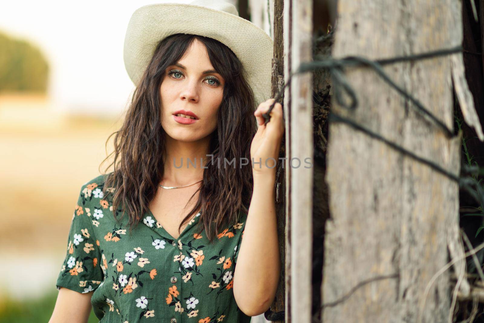 Beautiful hiker young woman, wearing flowered shirt, posing as a fashion model in the countryside.