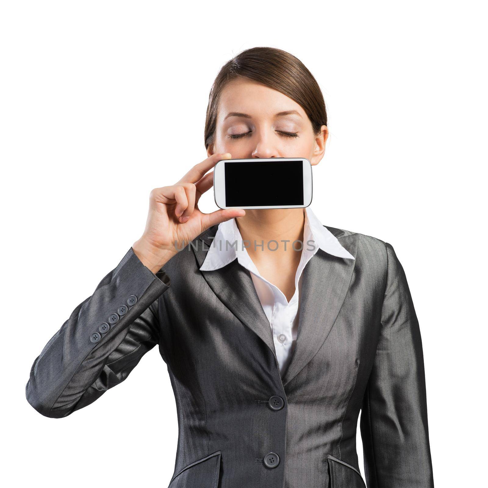 Pretty woman with closed eyes showing mobile phone near her face. Businesswoman holding smartphone with blank screen. Corporate businessperson isolated on white background. Mobile communication