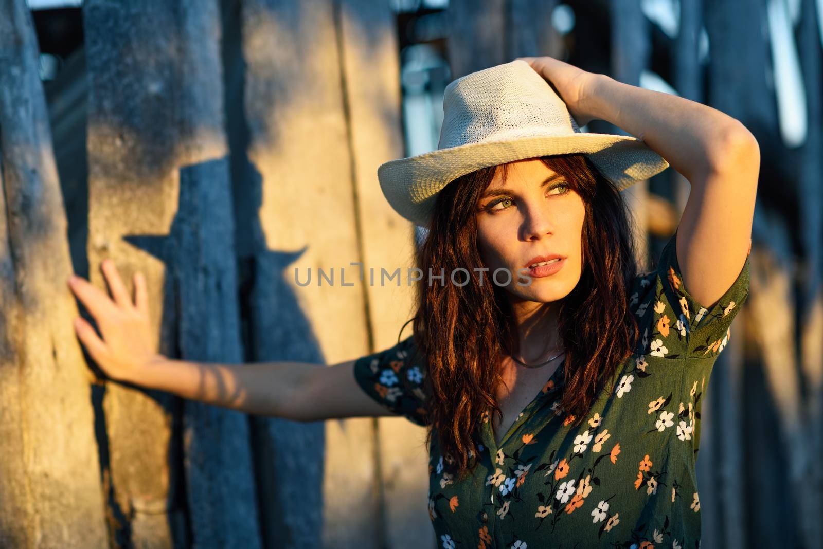 Beautiful hiker young woman, wearing flowered shirt, posing as a fashion model in the countryside.
