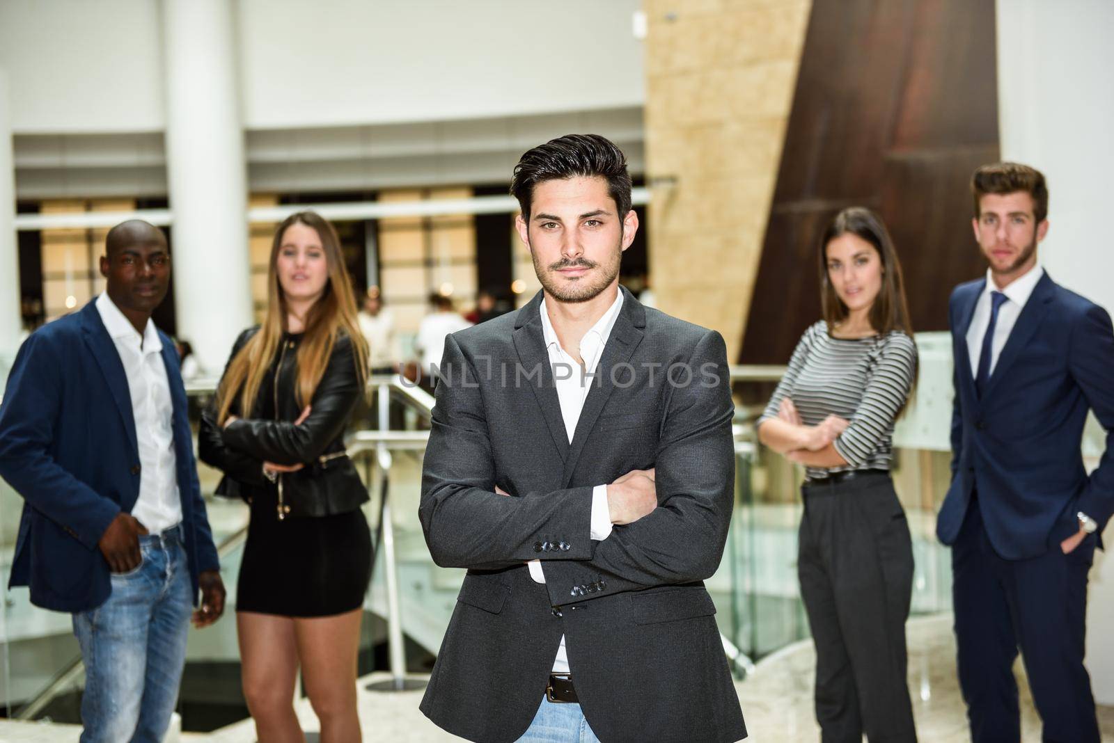 Businessman leader with arms crossed in working environment by javiindy