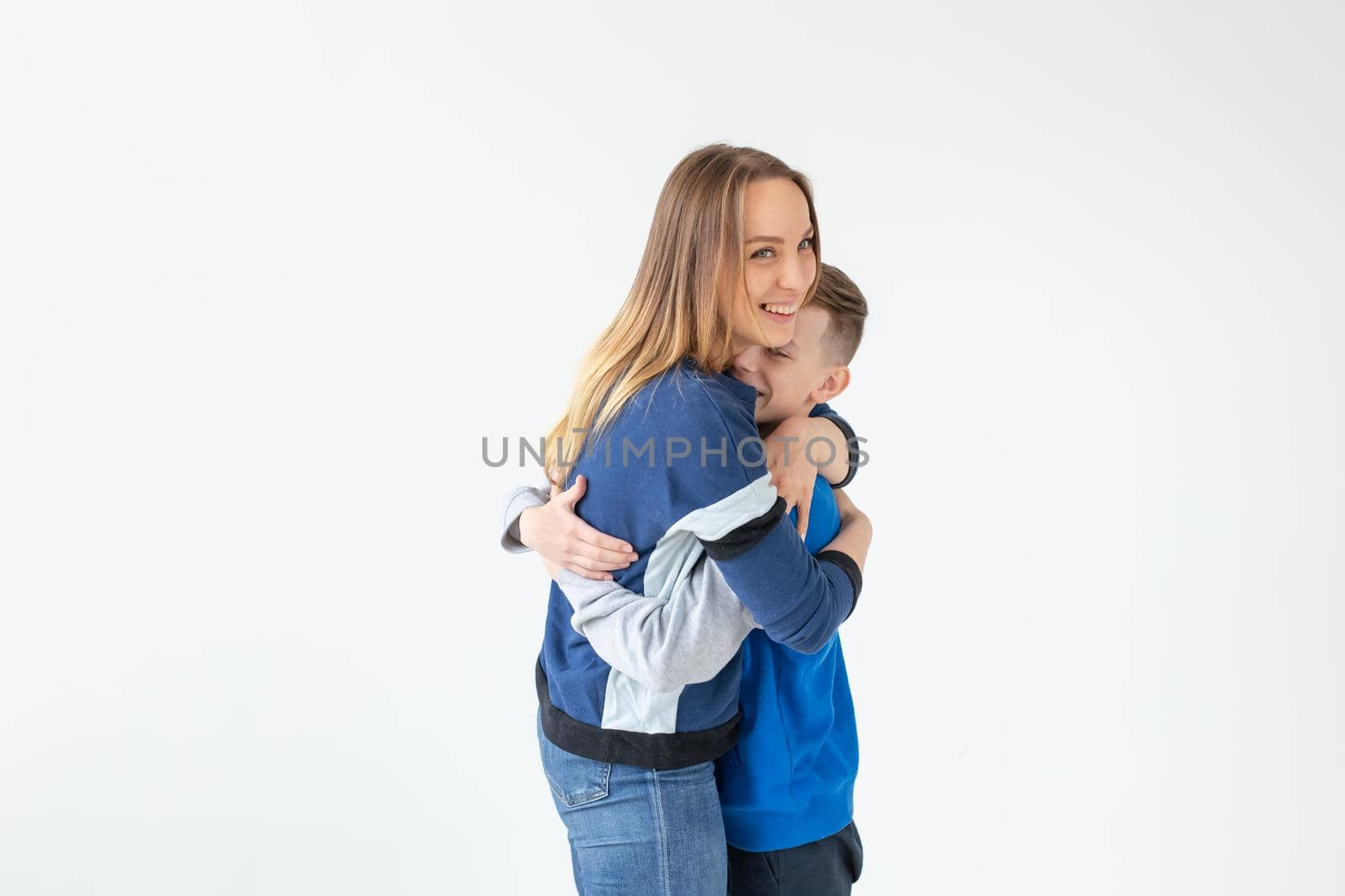 Cute smiling mother and son hug standing in their new living room and rejoicing in the move. The concept of warm family relationships and housewarming. Copyspace