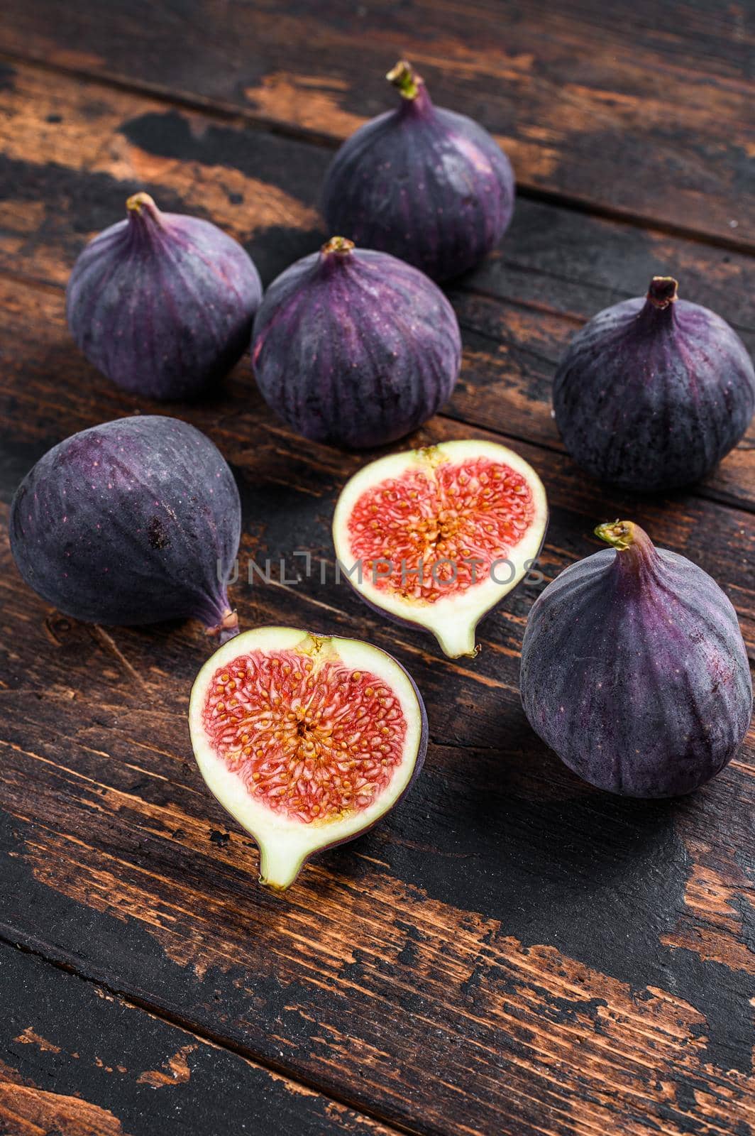 Purple figs on a wooden table. Dark wooden background. Top view by Composter