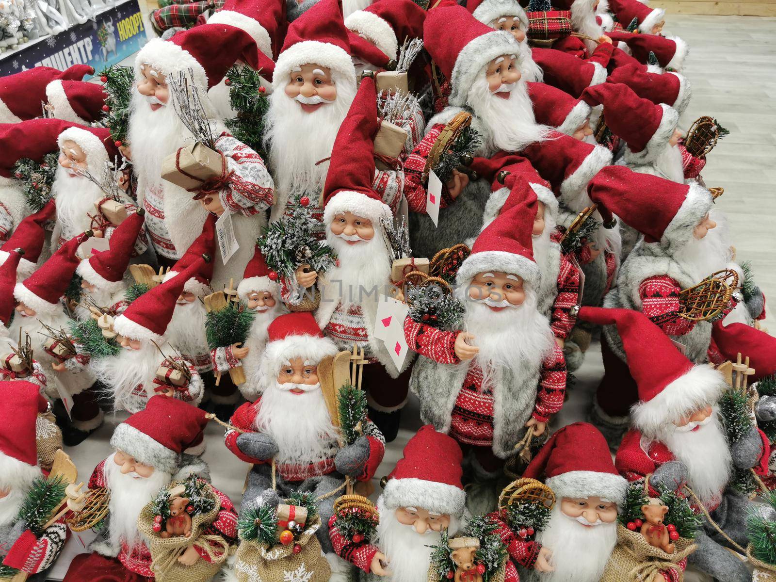 Many Santa Claus toys on a supermarket shelf for sale. Christmas collection in the store. Xmas decorations Manufacturers & suppliers concept. New Year.