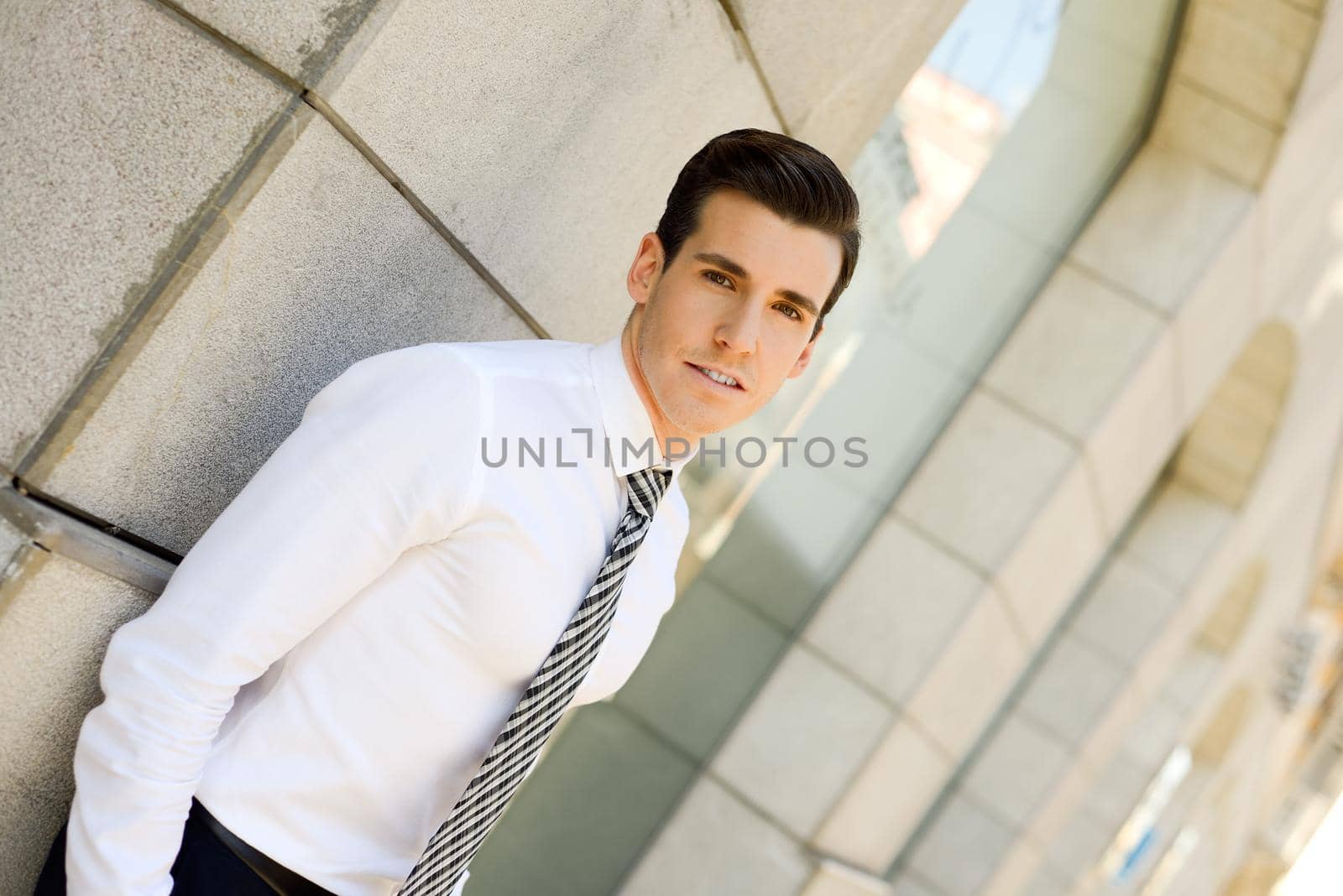 Portrait of attractive young businessman in urban background