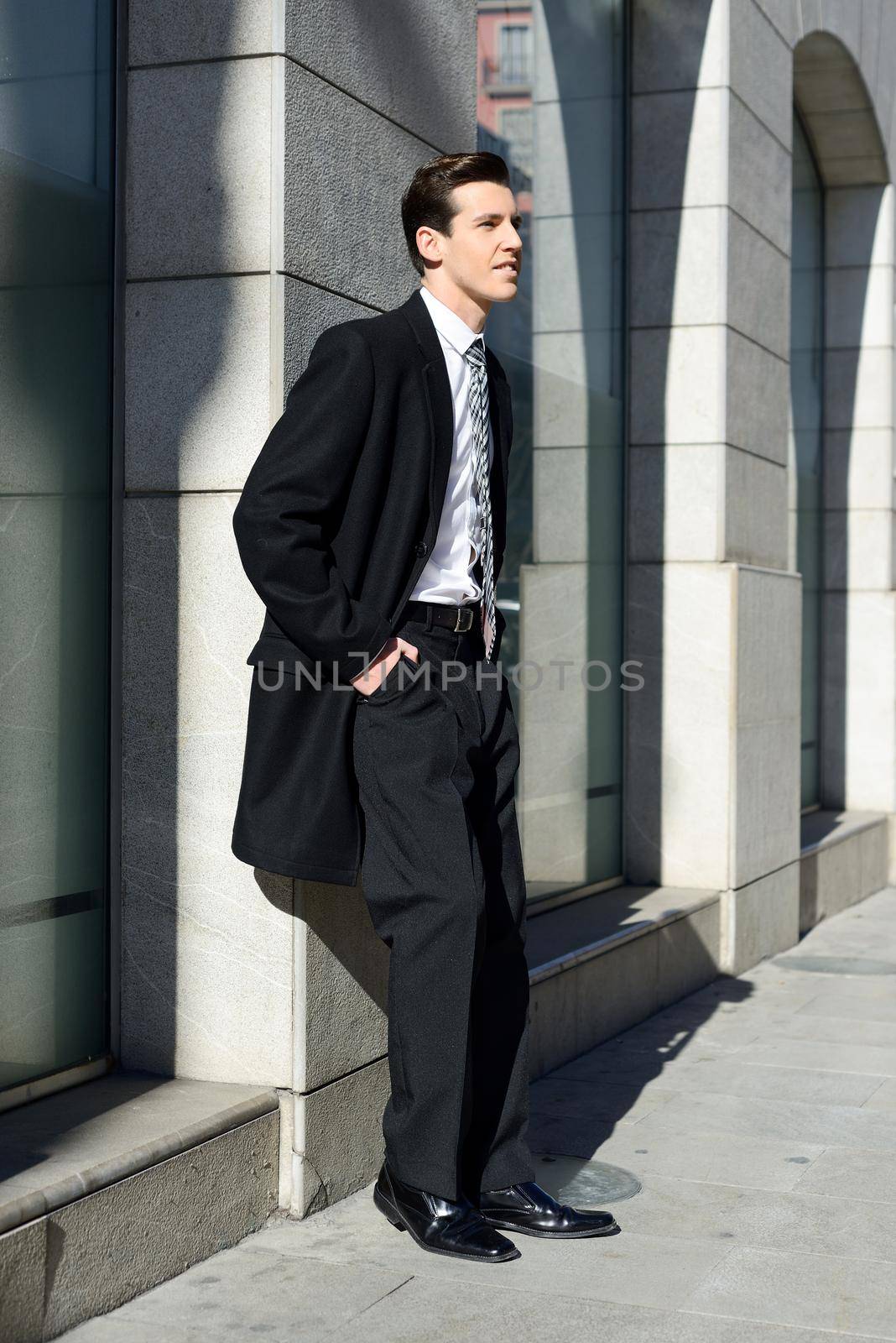 Portrait of attractive young businessman in urban background
