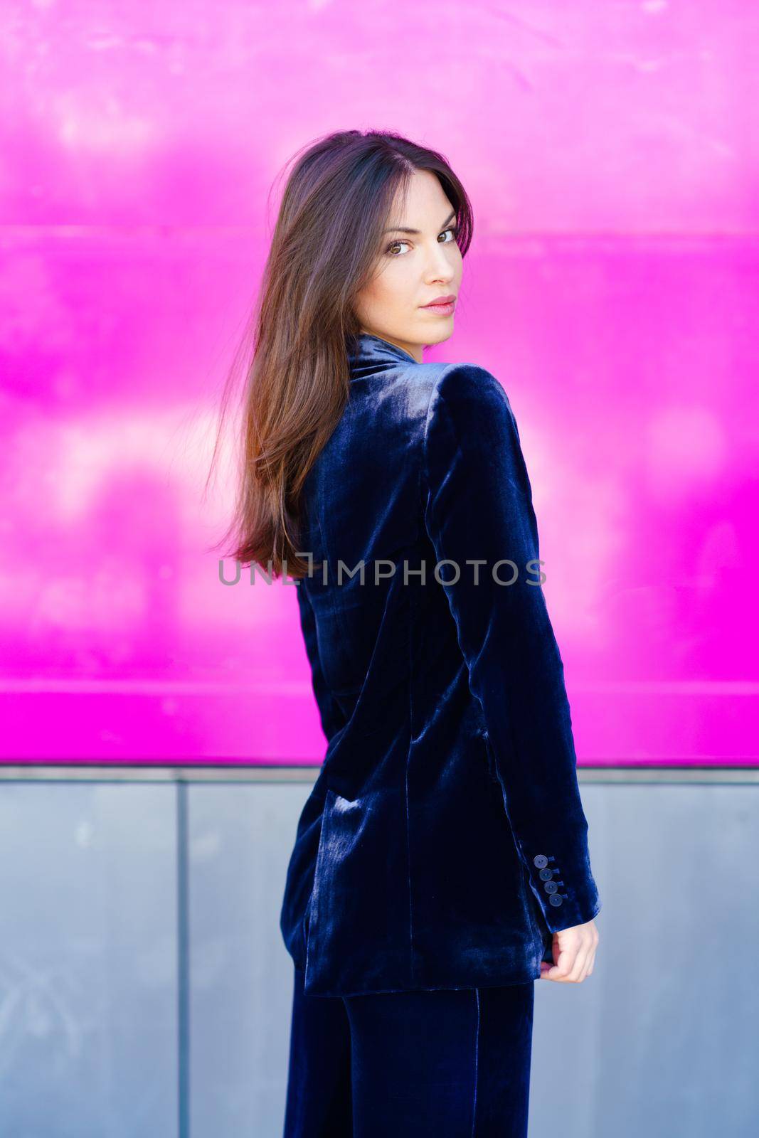 Woman wearing blue suit posing near a modern building. Lifestyle concept.