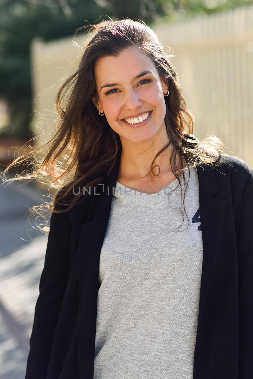 Portrait of beautiful woman smiling, wearing casual clothes in urban background