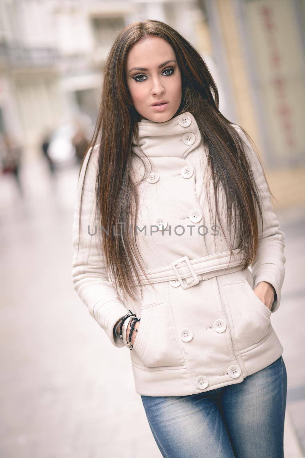 Portrait of a young woman, wearing casual clothes, with long hair in urban background