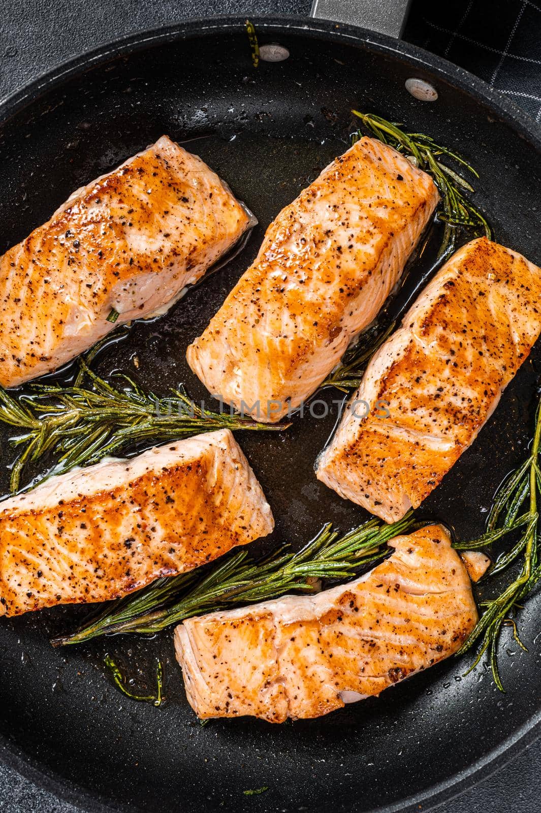 Grilled Salmon Fillet Steak in a pan. Black background. Top view by Composter