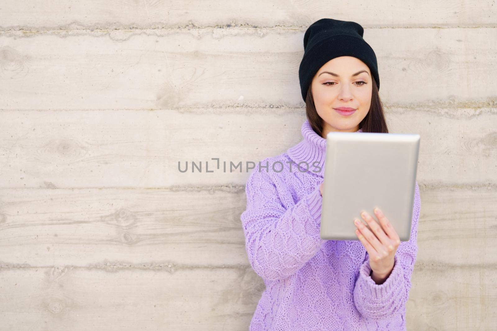 Female student in her twenties using digital tablet outdoors. Lifestyle concept.