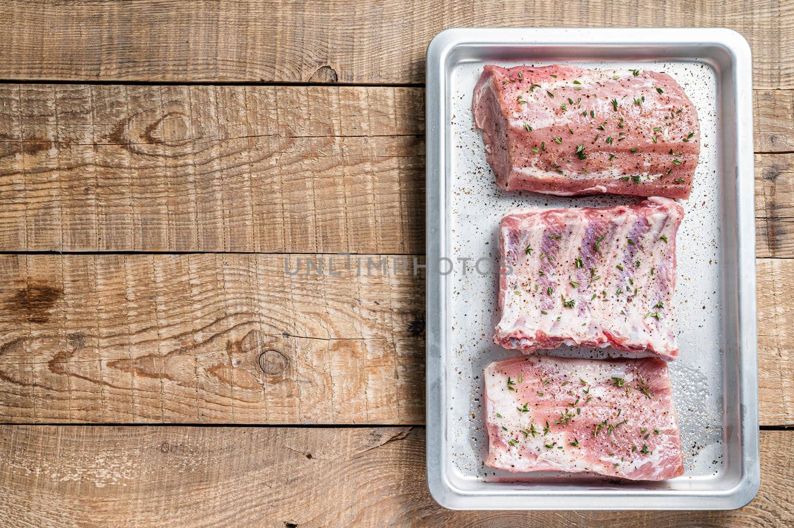 Set of Raw pork cuts, loin meat, spare ribs and brisket. Wooden background. Top view. Copy space.