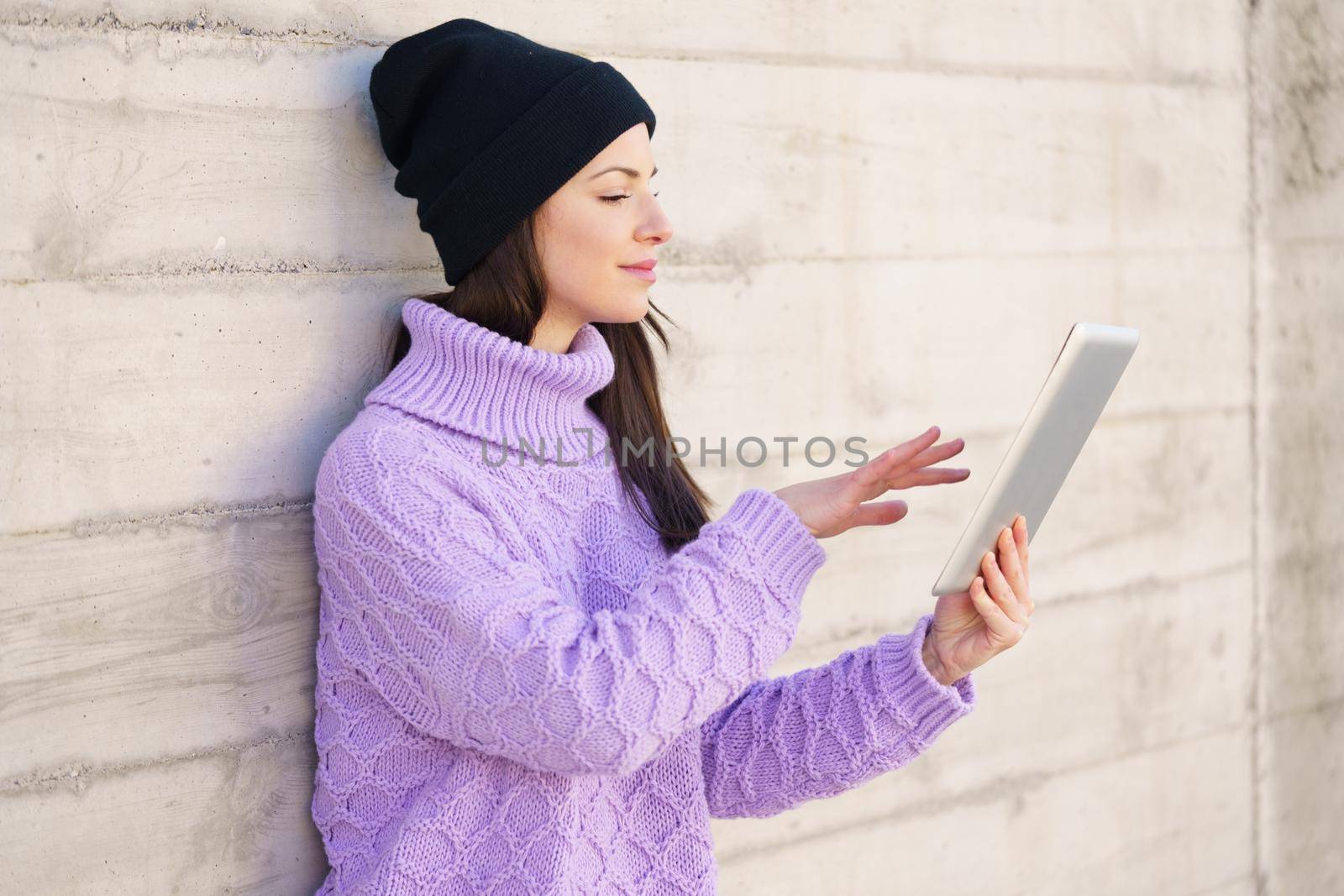 Female student in her twenties using digital tablet outdoors. by javiindy