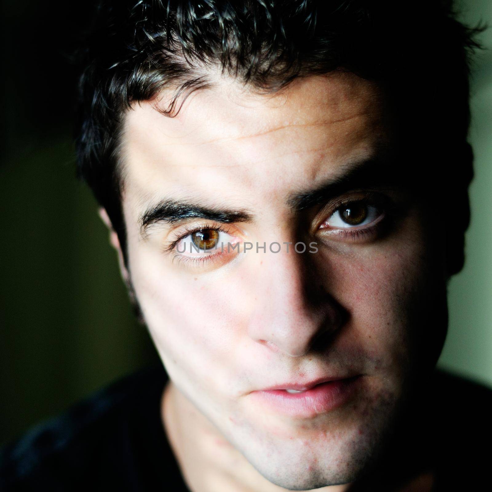 Portrait of a young casual man on black background