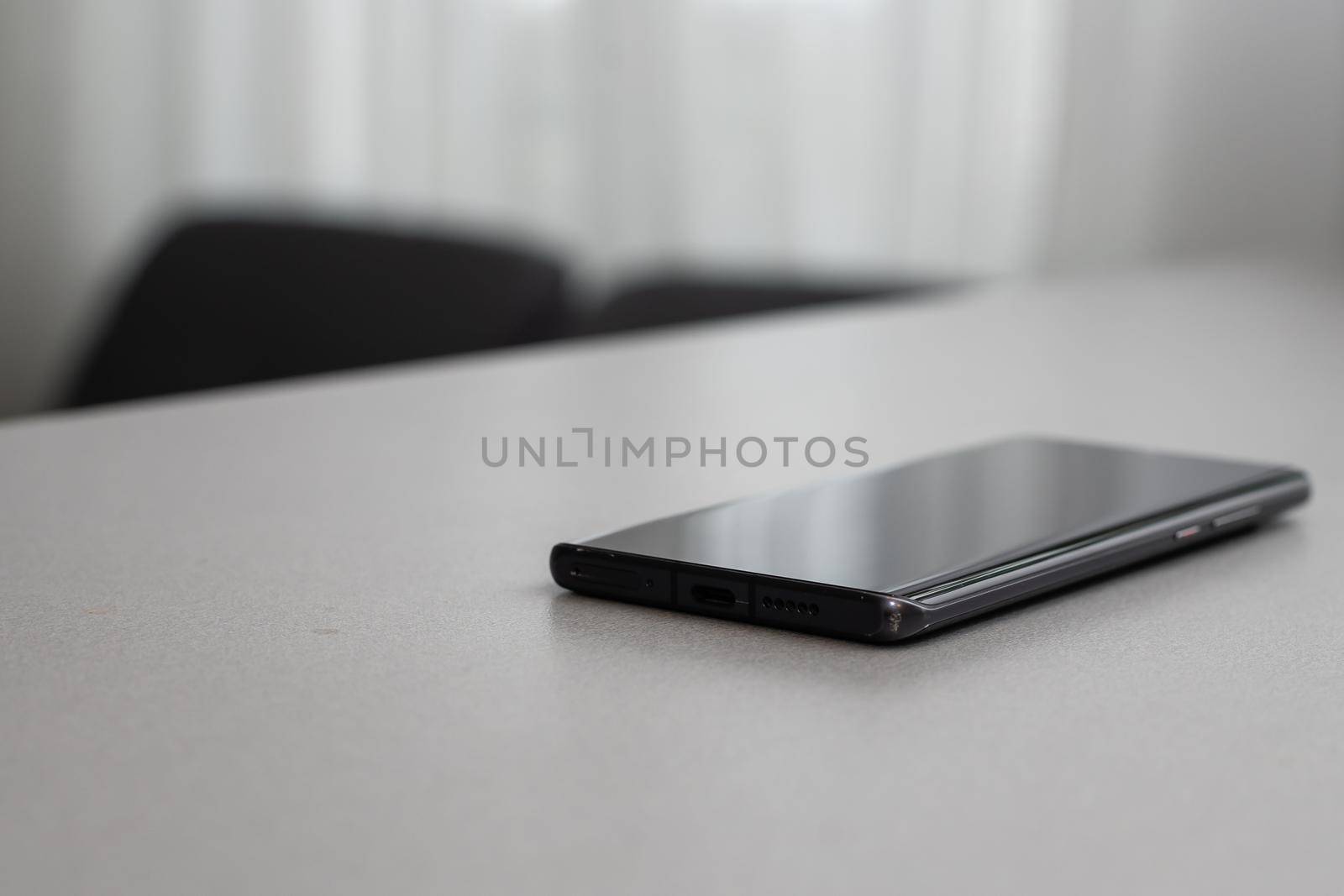 A single mobile phone on gray table by Andelov13