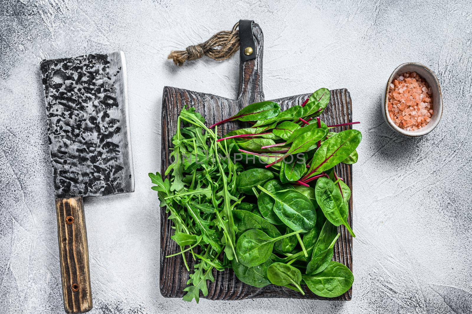 Fresh mixed greens, spinach, swiss chard and arugula. White background. Top view.