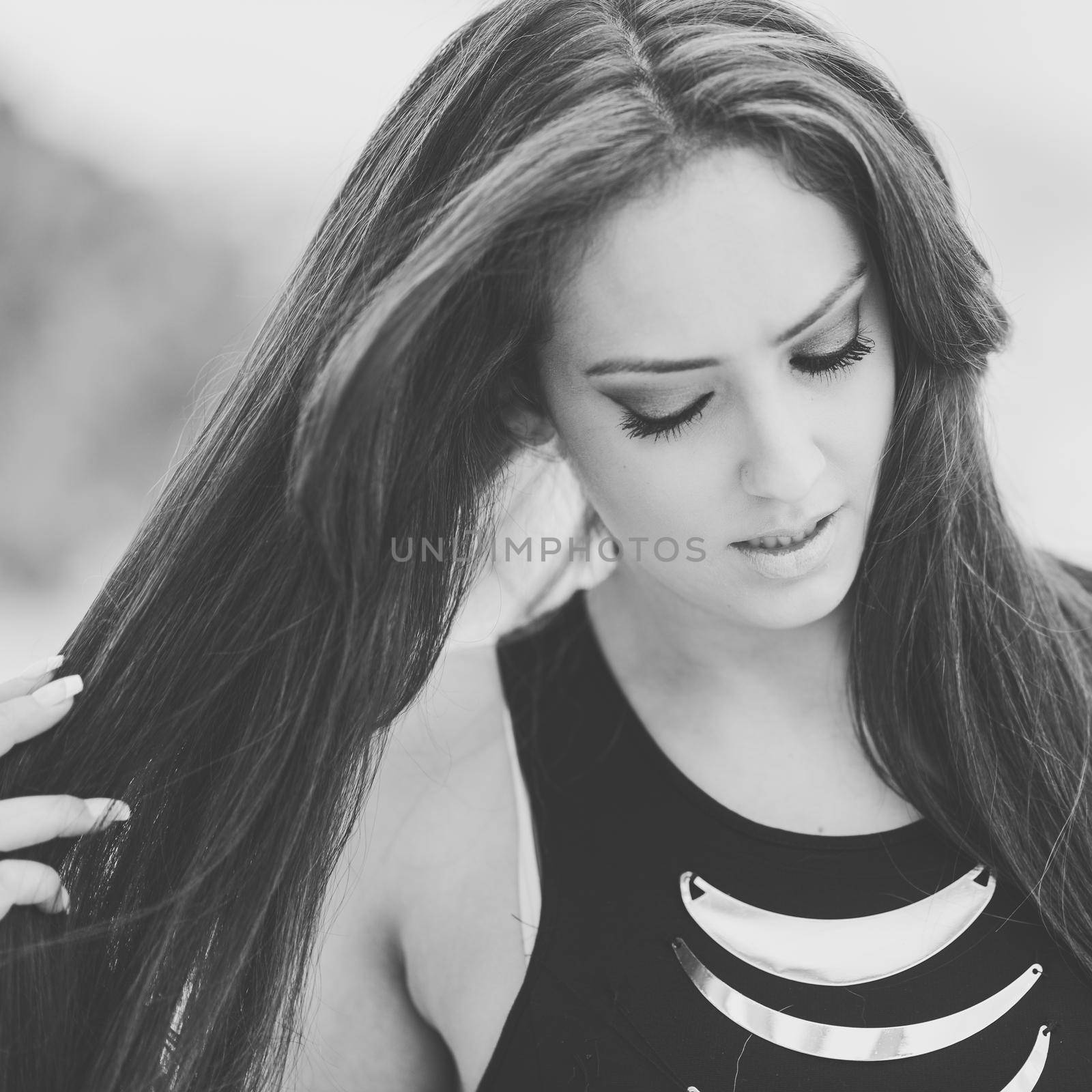 Portrait of a young woman, wearing dress, with long hair in urban background