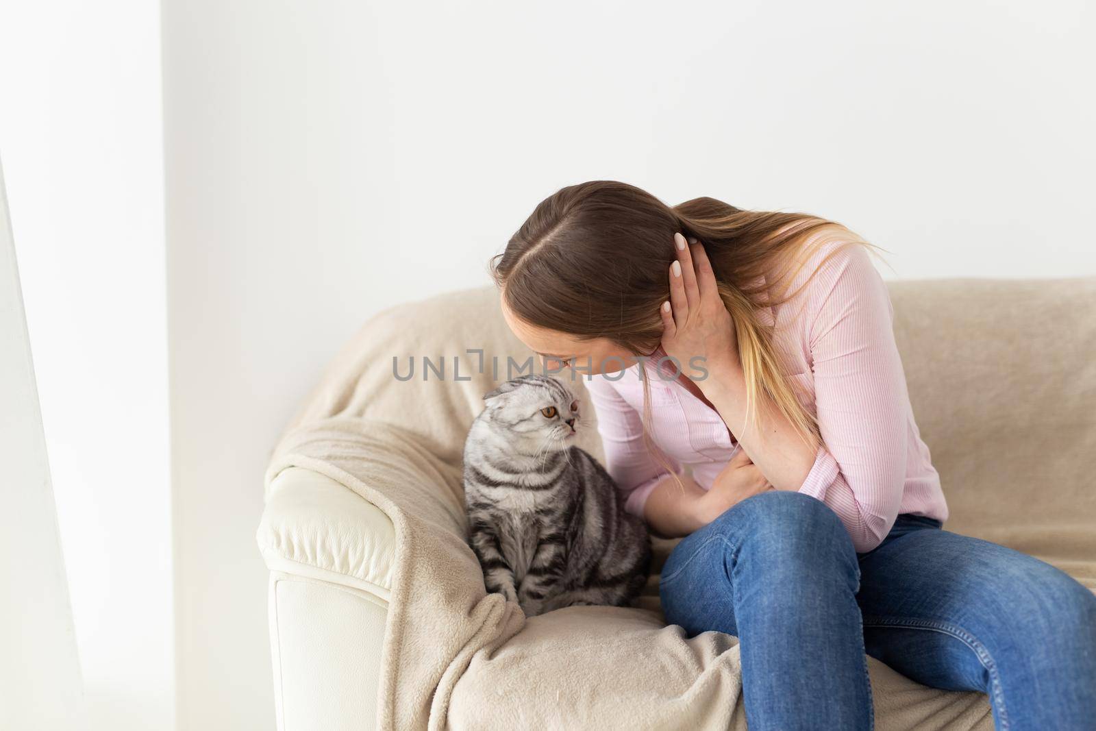 Woman at home kissing her lovely fluffy cat. Gray tabby cute scottish fold cat. Pets and lifestyle concept. by Satura86