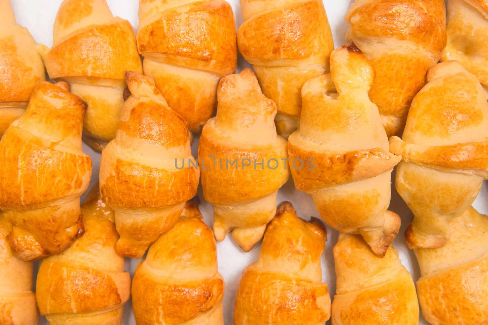 Fresh homemade baked goods. Croissants in heap background. Buns on the counter at the bakery, close up by AYDO8