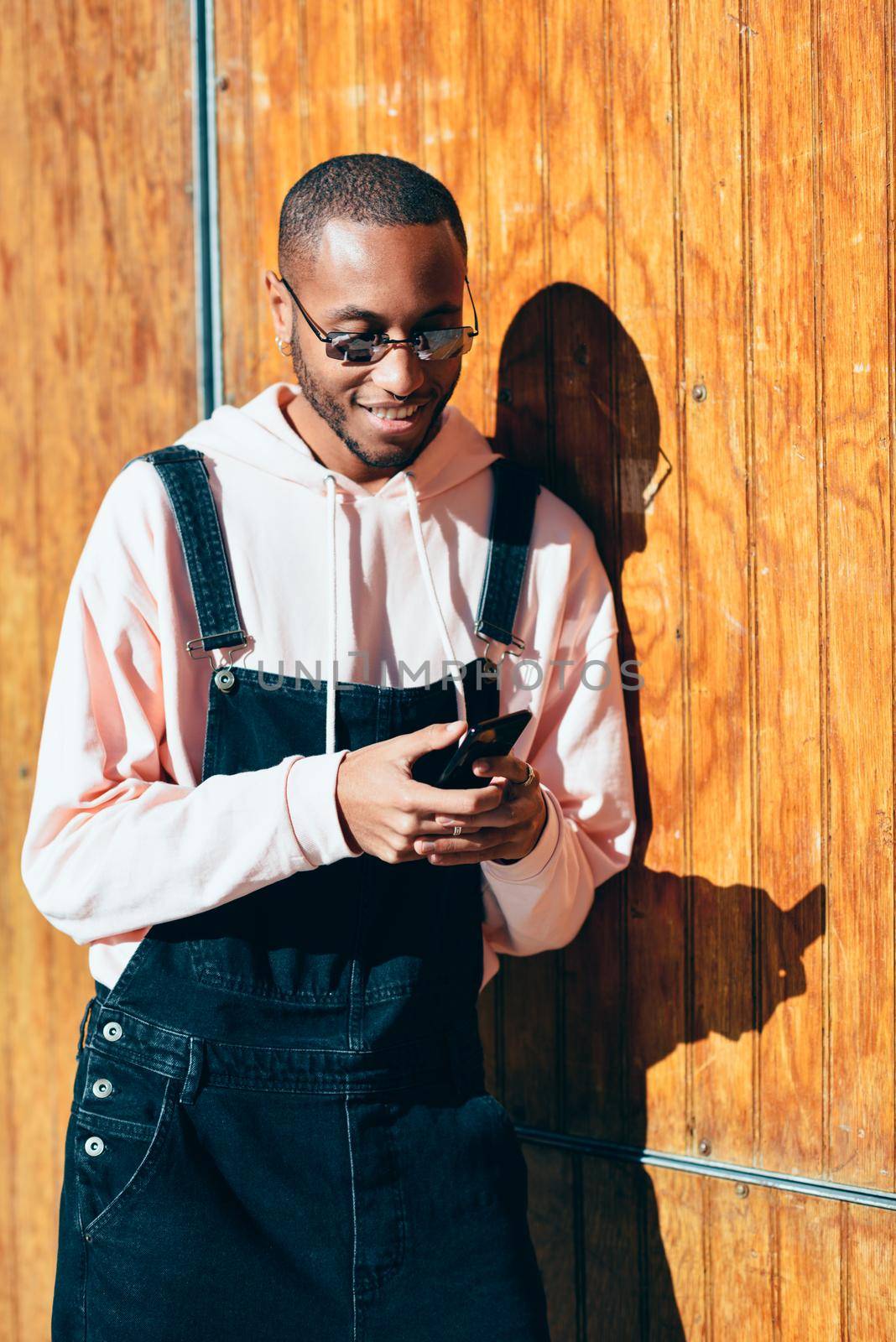 Young black man using smart phone outdoors by javiindy