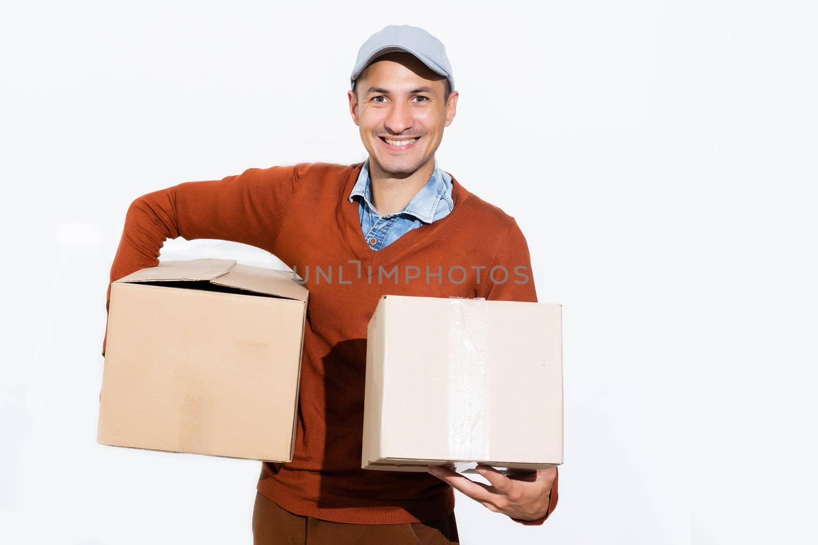 Smiling delivery man giving cardbox on white background.