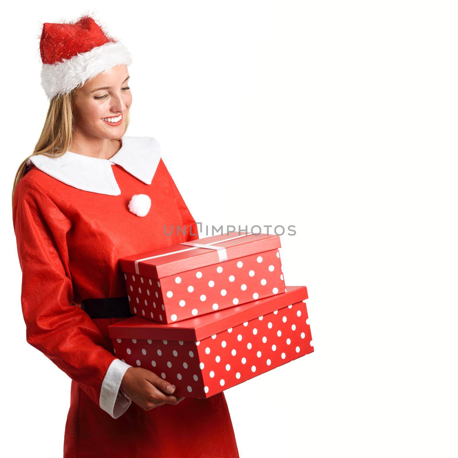 Blonde woman in Santa Claus clothes smiling with gift boxes in her hands. Young female with blue eyes, isolated on white