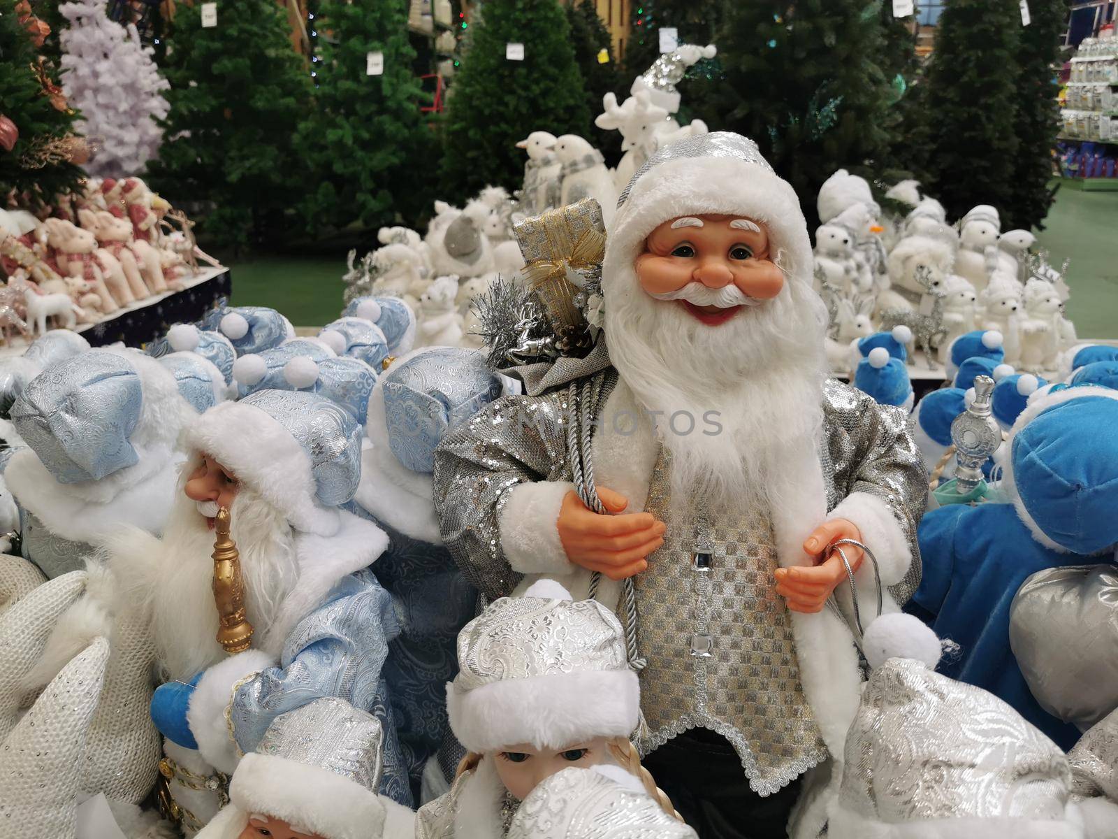 Many Santa Claus toys on a supermarket shelf for sale. Christmas collection in the store. Xmas decorations Manufacturers & suppliers concept. New Year.